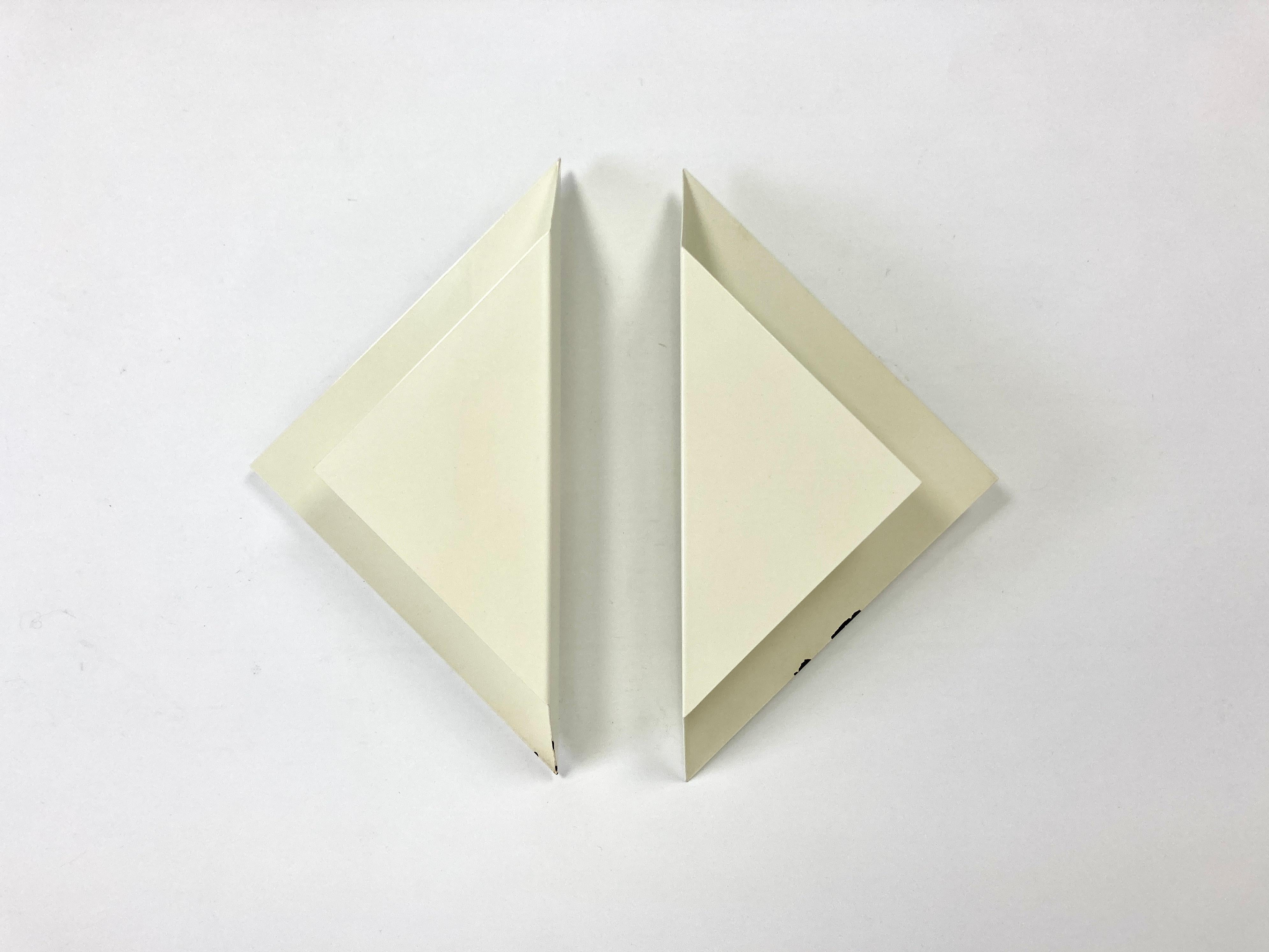Pair of vintage mid century French wall lights, circa 1960-70.

Minimalist triangular design.

Original slightly off-white lacquered finish.

They can be wall mounted at any desired angle and sit slightly away from the wall.

Sourced from an