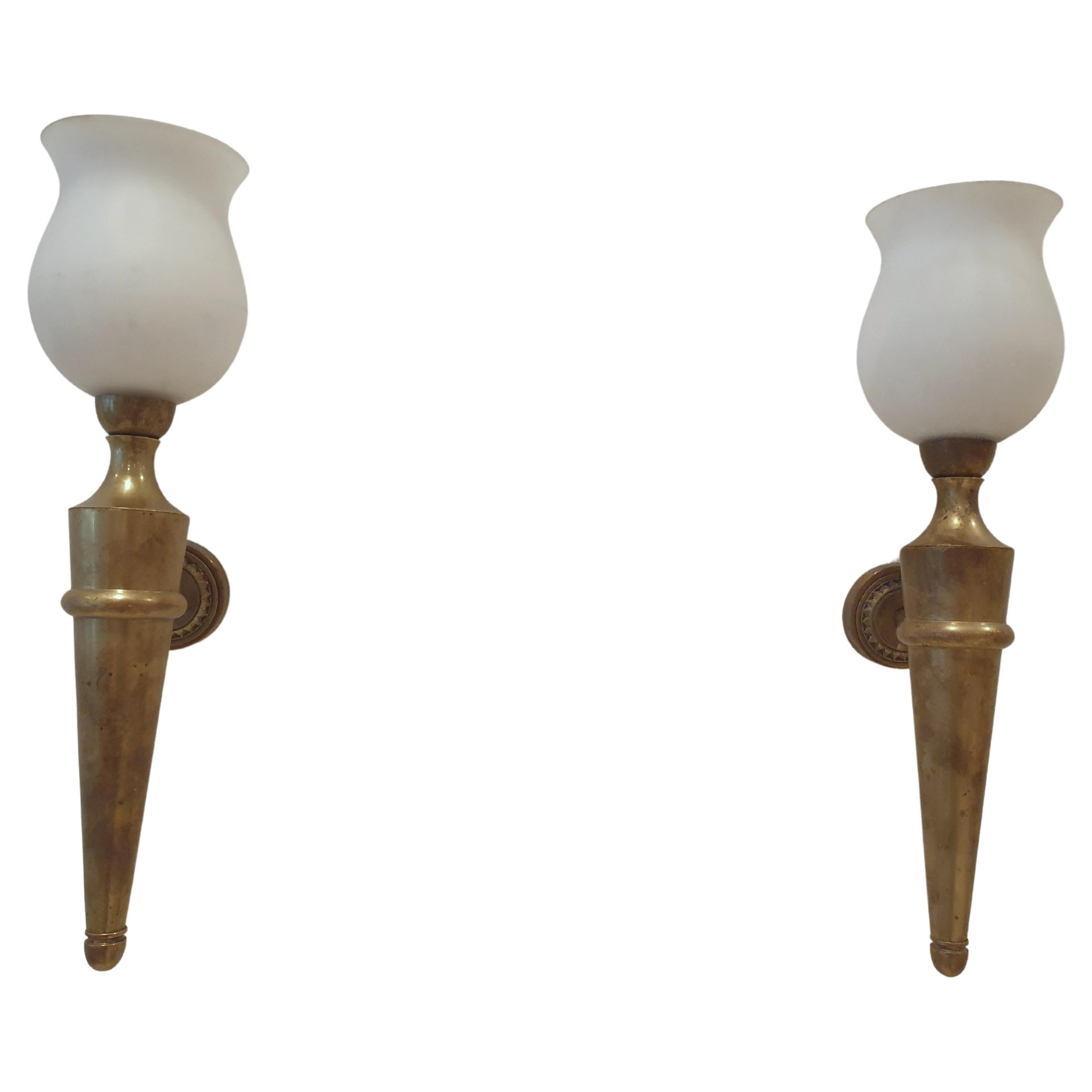 Pair of fine quality patinated bronze wallights by Atelier Jean Perzel. They come complete with original glass shades. These elegant wallights are finely detailed and of a heavy weight denoting quality and are in the classical form of torcheres. 