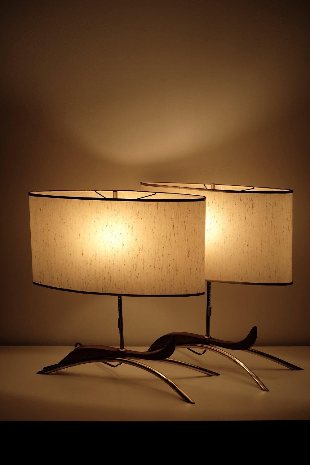 Pair of Mid Century walnut and brass table lamps with original oval shades.