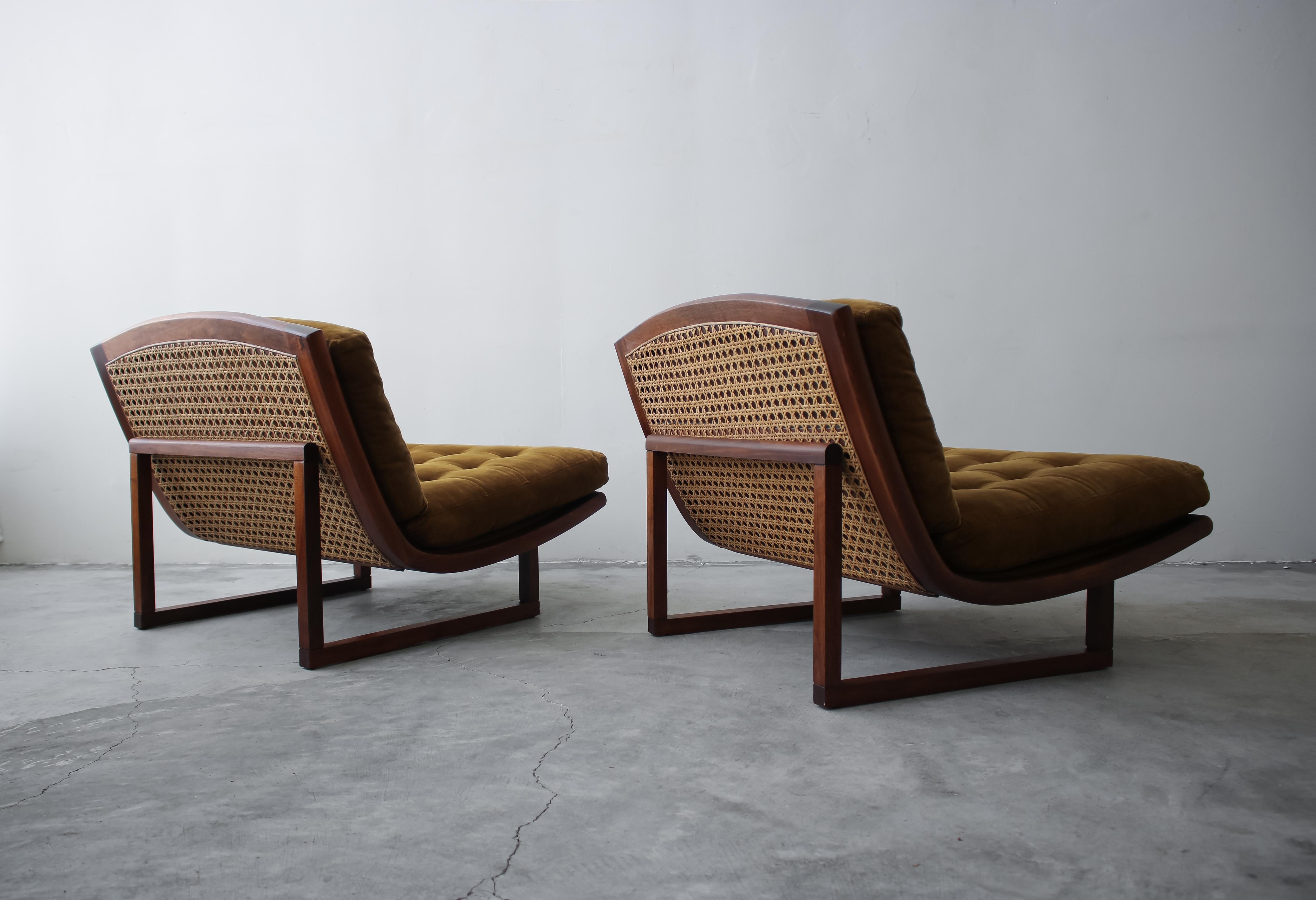 If you're looking for an extremely rare and unique pair of midcentury lounge chairs, with the most amazing details and lines, look no further. These chairs are absolutely stunning from EVERY Angle. A gorgeous walnut and cane scoop sits on solid