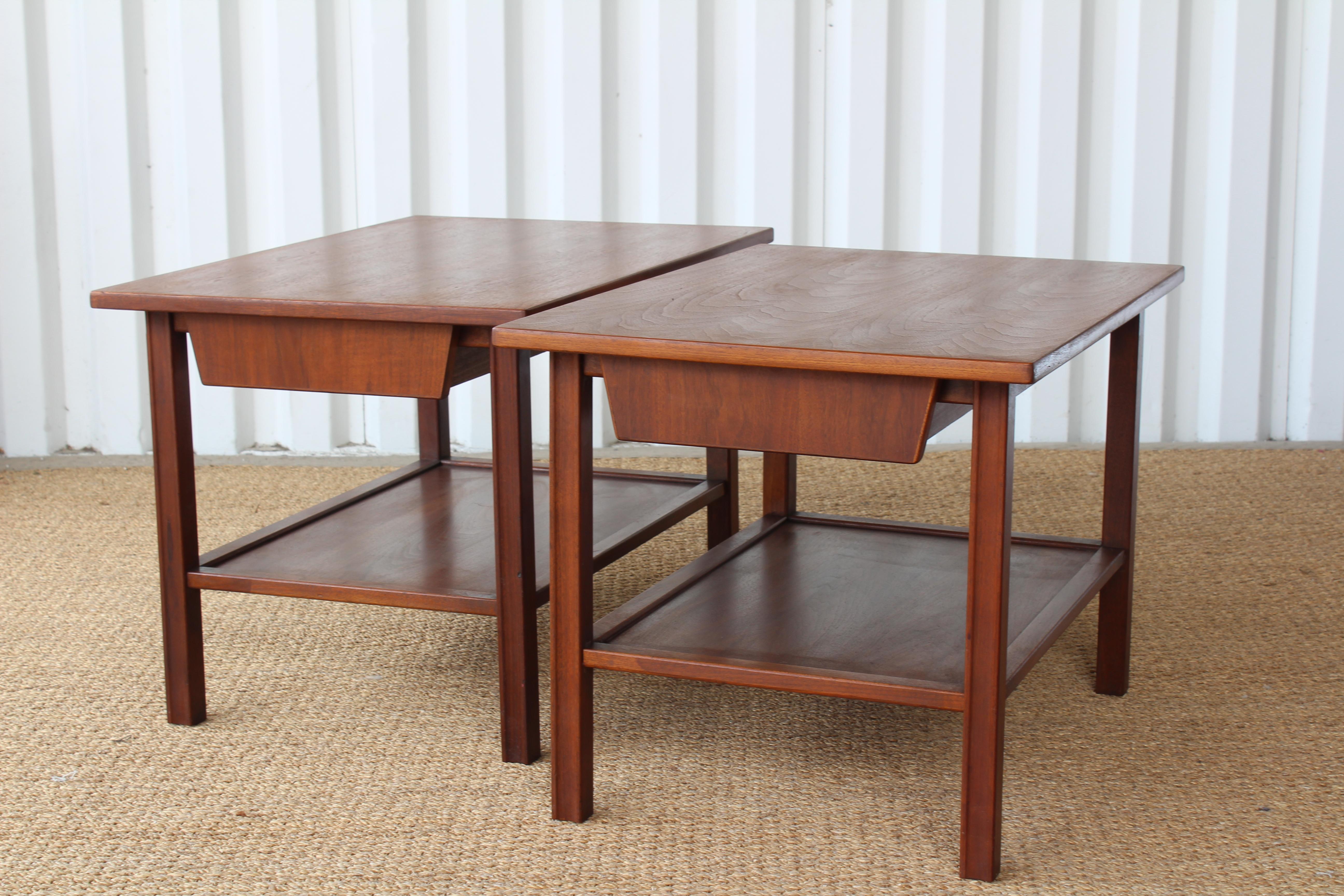 Pair of Mid-Century Modern 1960s walnut end tables. Each end table is in great condition and features a single drawer and bottom shelf. Sold as a pair.