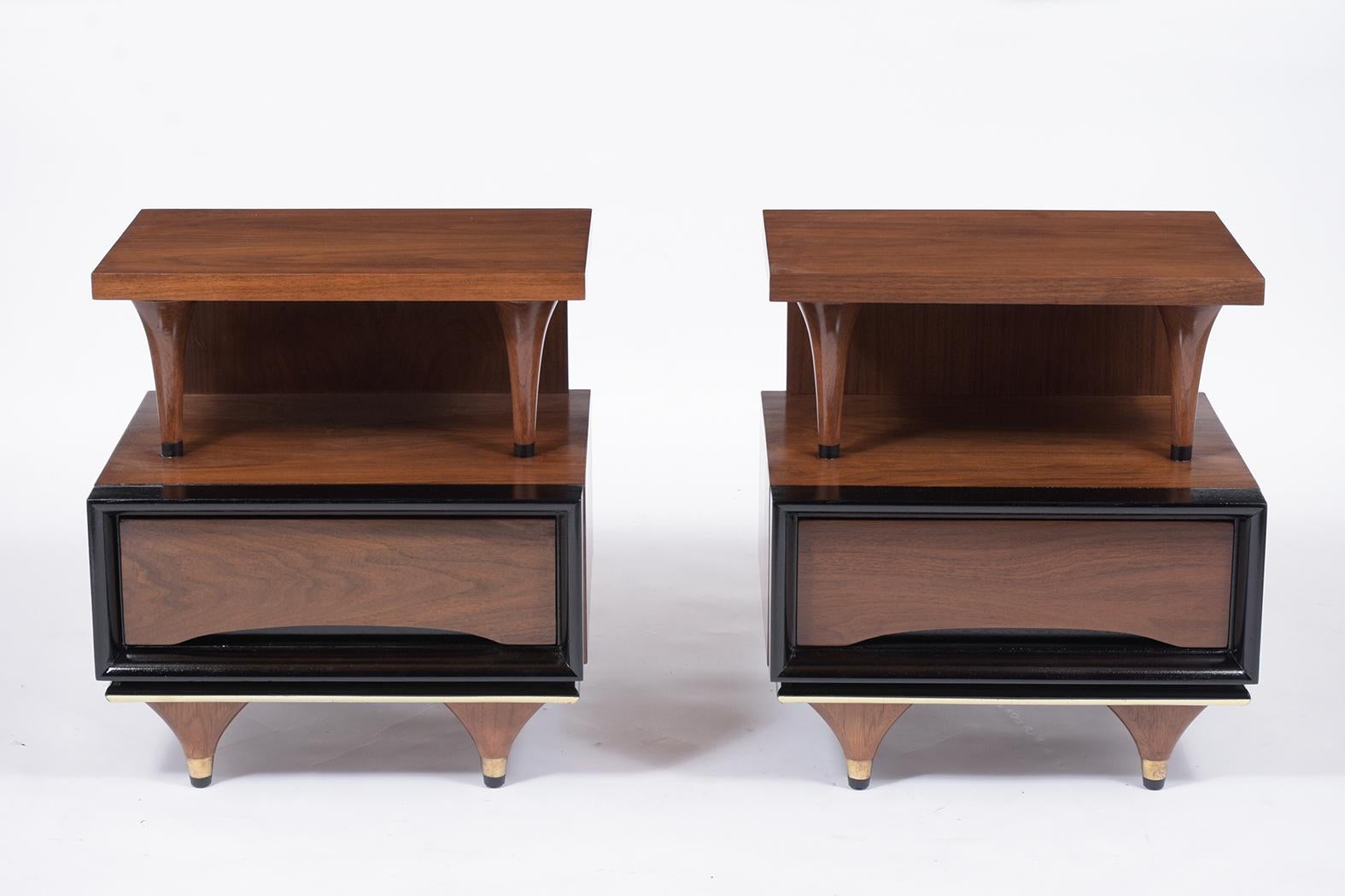 A pair of sleek Mid-Century Modern nightstands that have been fully restored, is handcrafted out of walnut wood and have a new rich walnut and ebonized combination color with a lacquer finish. These nightstands come with a small top open and open