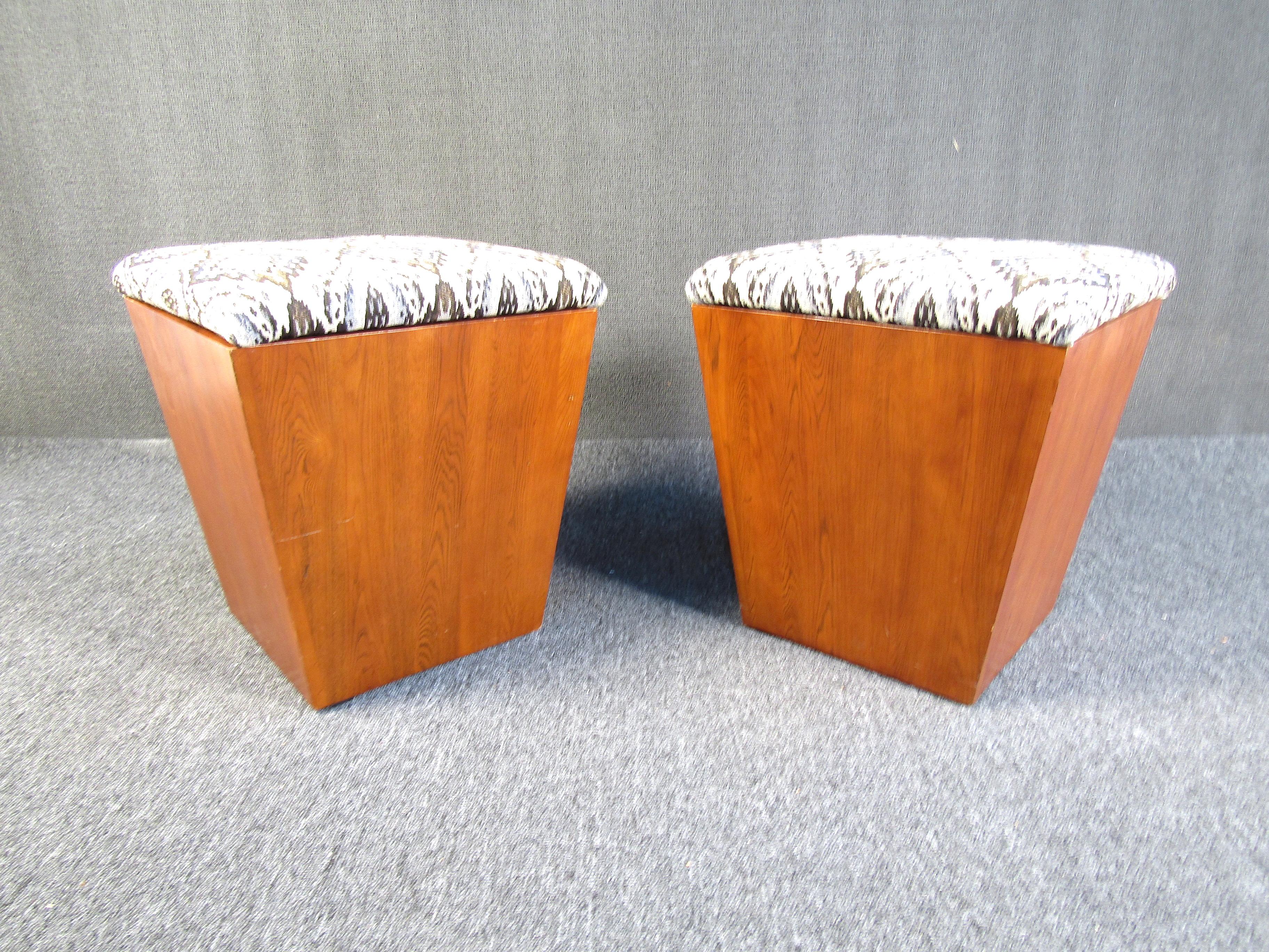 This pair of walnut ottomans feature a plush upholstery top as well as ample internal storage for both pieces. Perfect for keeping those essentials you don't want on display still close at hand. Please confirm the item location with the dealer.