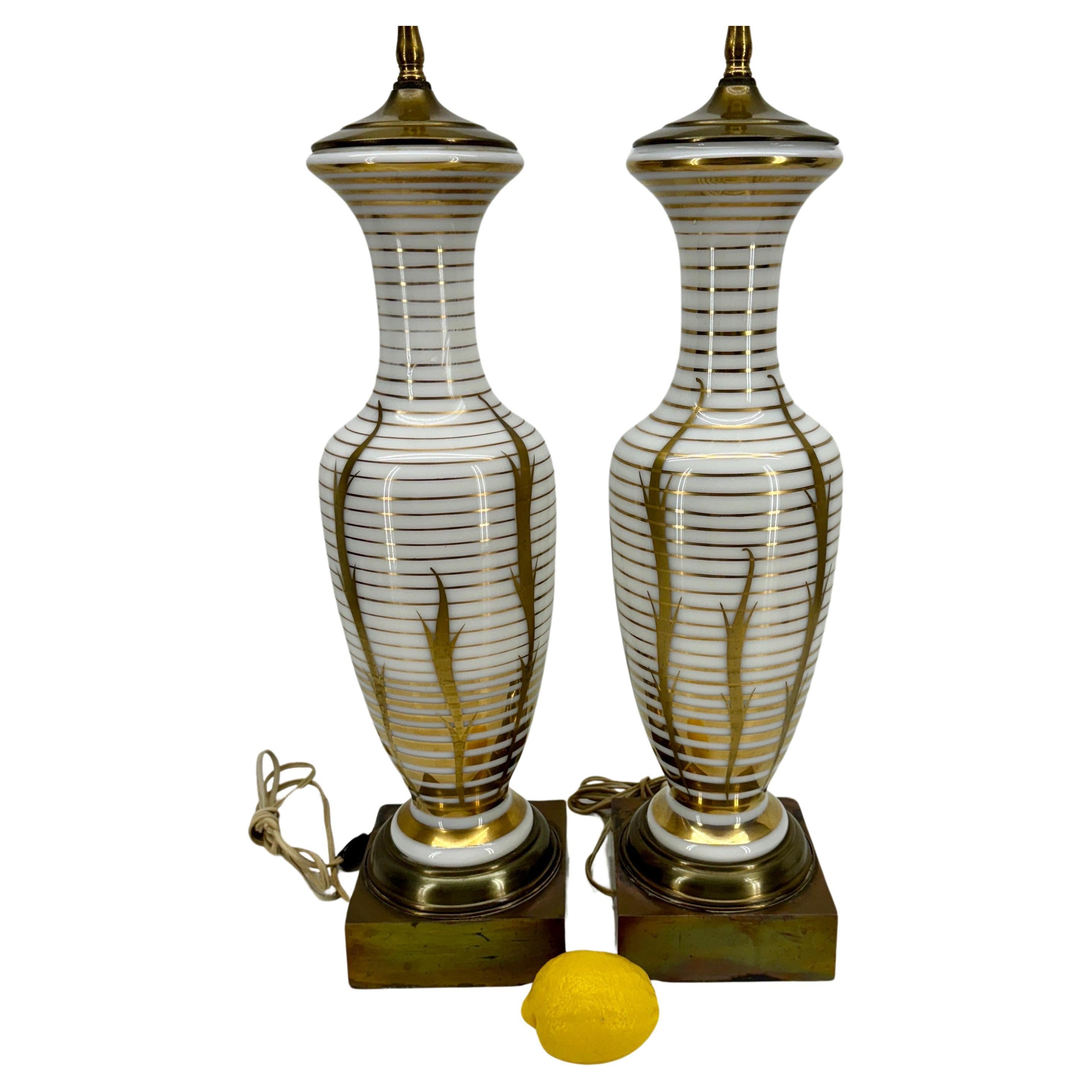 Opaline Glass Gilt Gold Decorated Table Lamps, A Pair

Illuminate your home with these Opaline Glass with gold-banded and striped Mid Century Modern Table Lamps. These exquisite lamps are not only a source of light but also a statement of luxury and