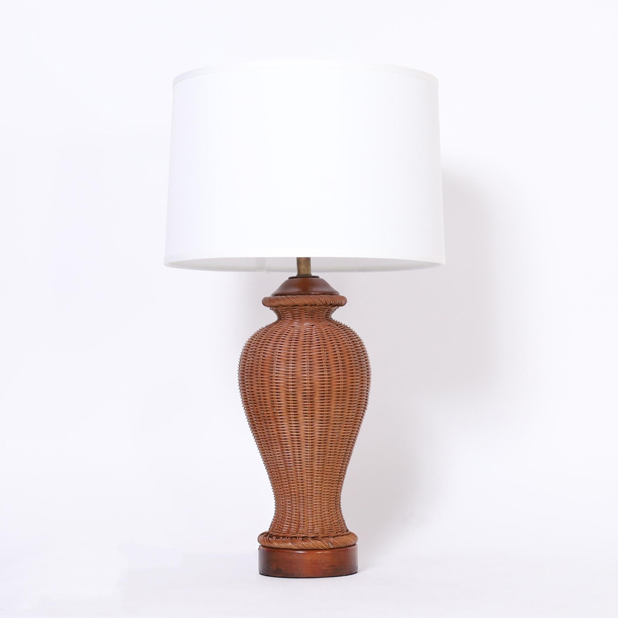 Earthy pair of mid century table lamps crafted in stick wicker in classic form with mahogany caps and bases.