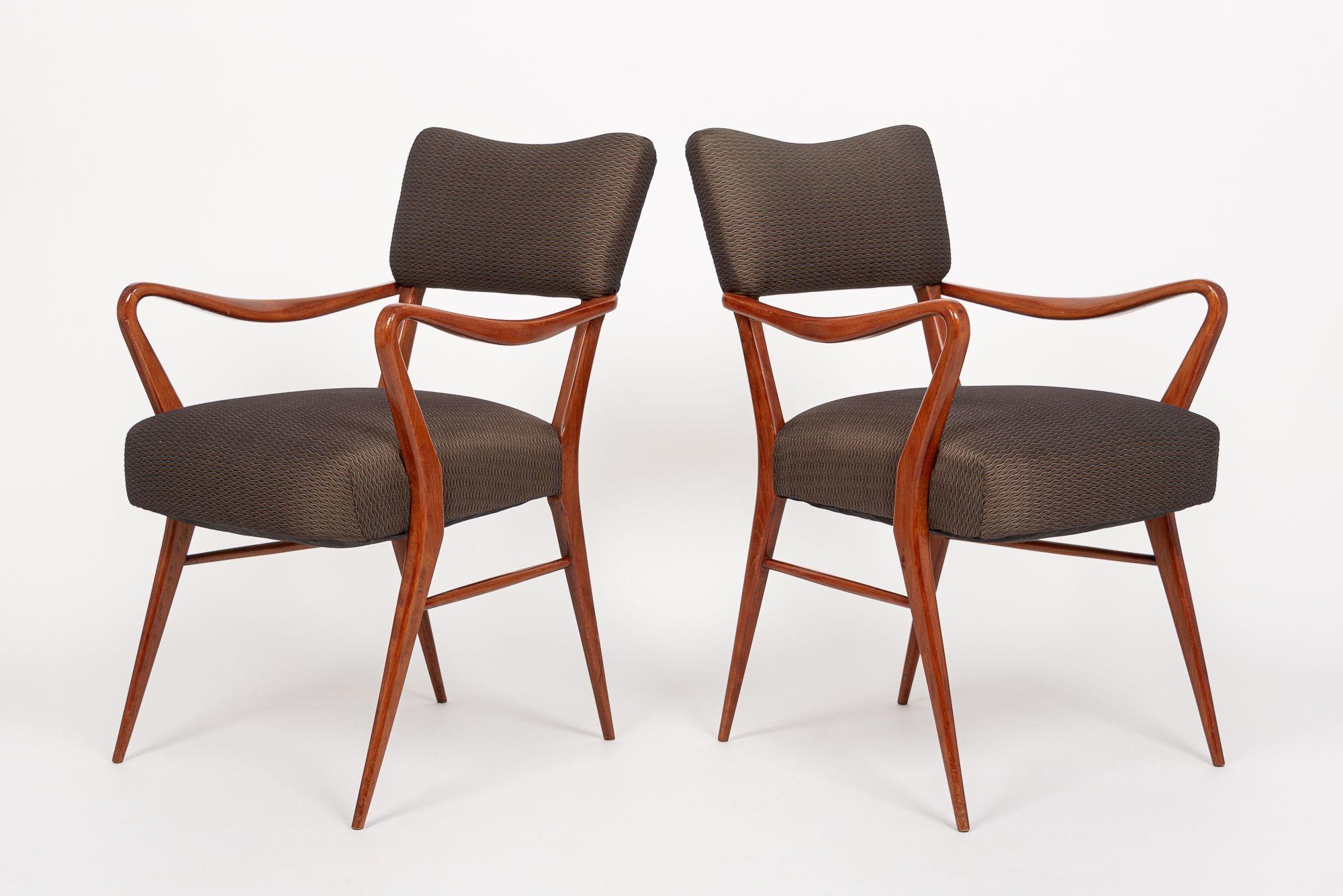 This beautiful pair of vintage mid century modern arm chairs attributed to mid century Italian designer Gio Ponti are circa 1950. The distinctive design features sculptural, lacquered solid wood frames with clean, elegant lines and gentle, organic