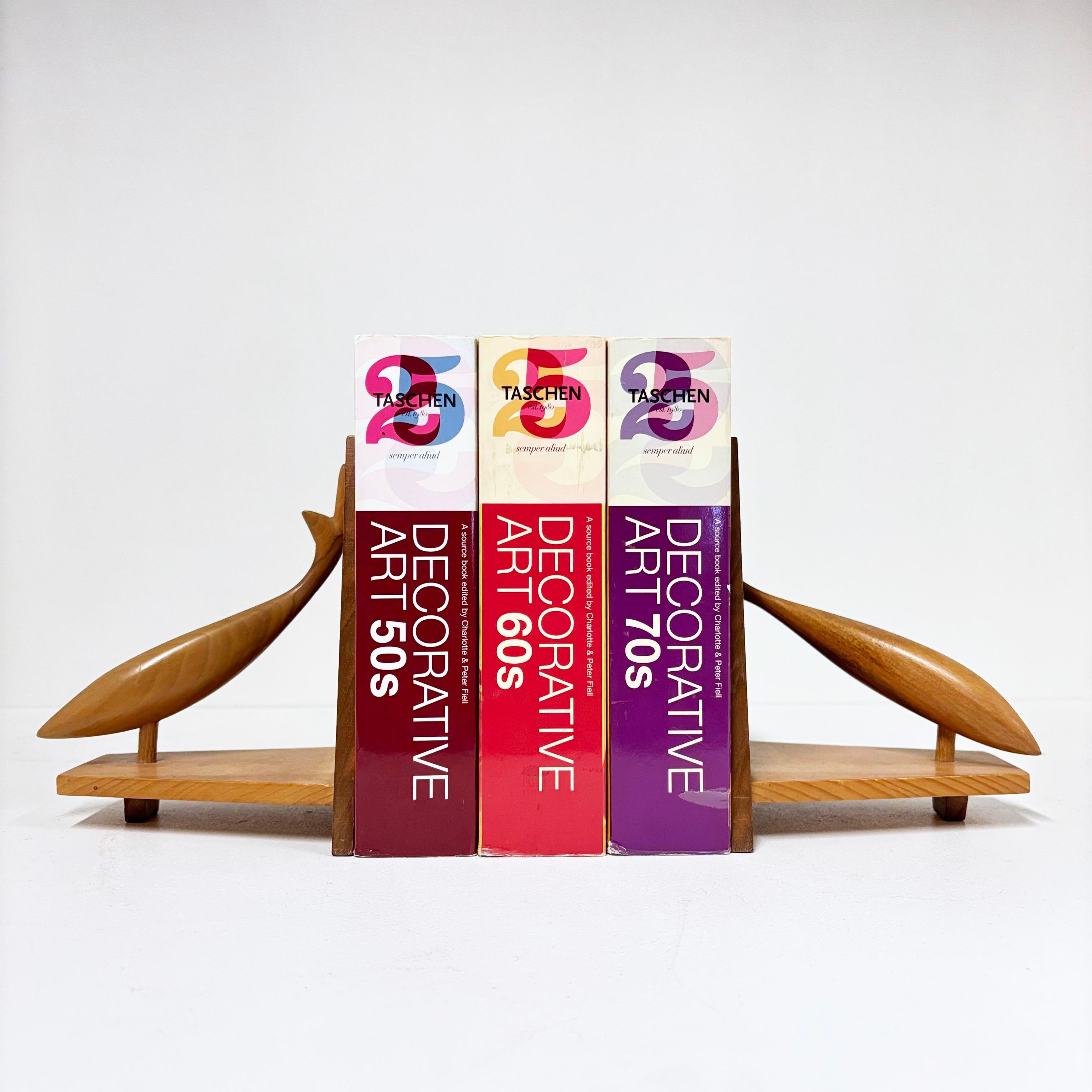 Mid Century solid wood bookends dating from the 1960's. 
With leaping salmon wood carvings. The end of one fish tail has a broken piece, although this is not visible when arranged on a shelf with books.
A nice accent to any home library or book