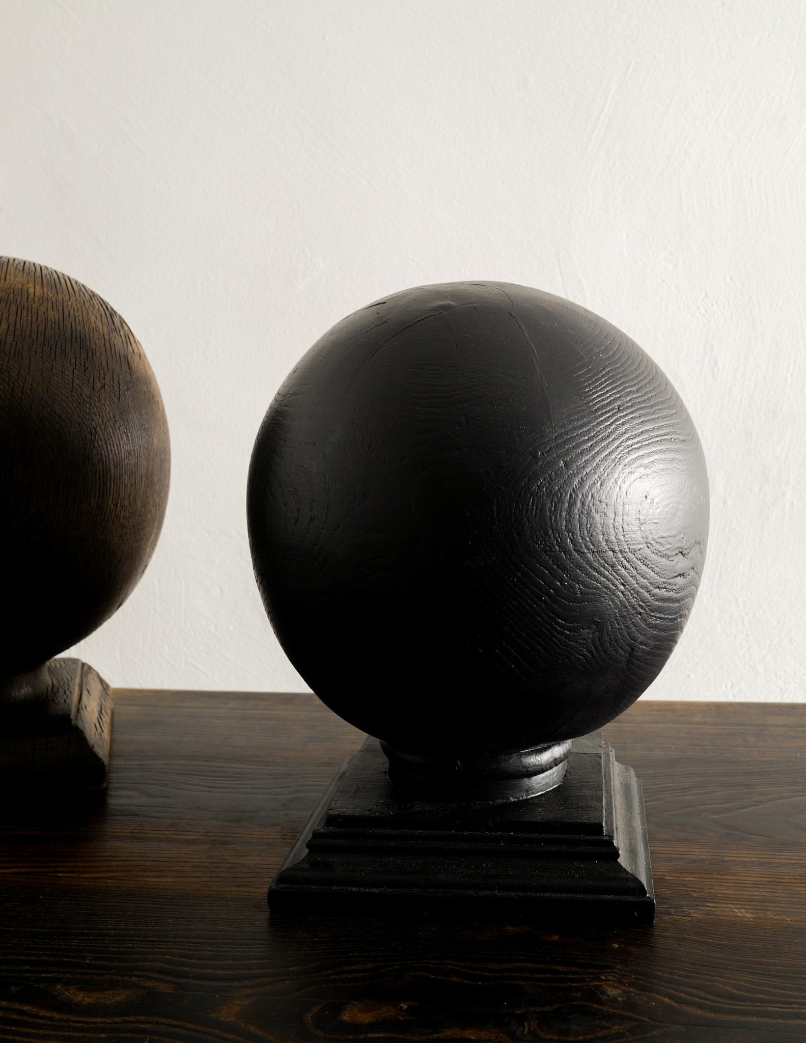 Pair of mid century globe sculptures in solid oak and ebonized pine. Both sculptures are in great condition and showing minimal signs of use. Perfect as they are or as bookends etc. 

Dimensions: Brown: H: 39 x W: 29 x D: 25 cm Black: H: 34 x W/D: