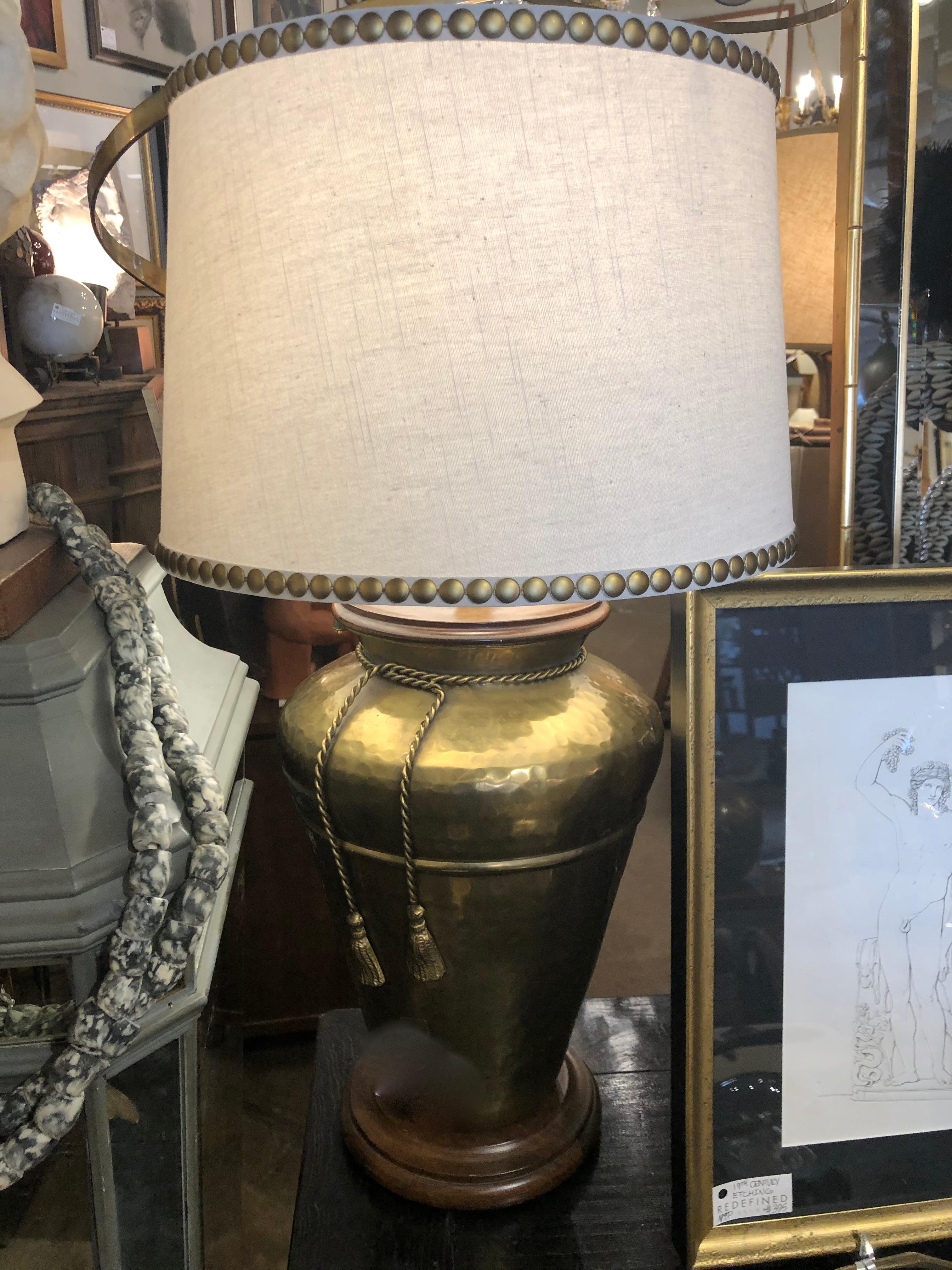 Pair of mid-20th century Frederick Cooper subtly hammered brass table lamps with applied brass rope tassels set upon walnut bases.
