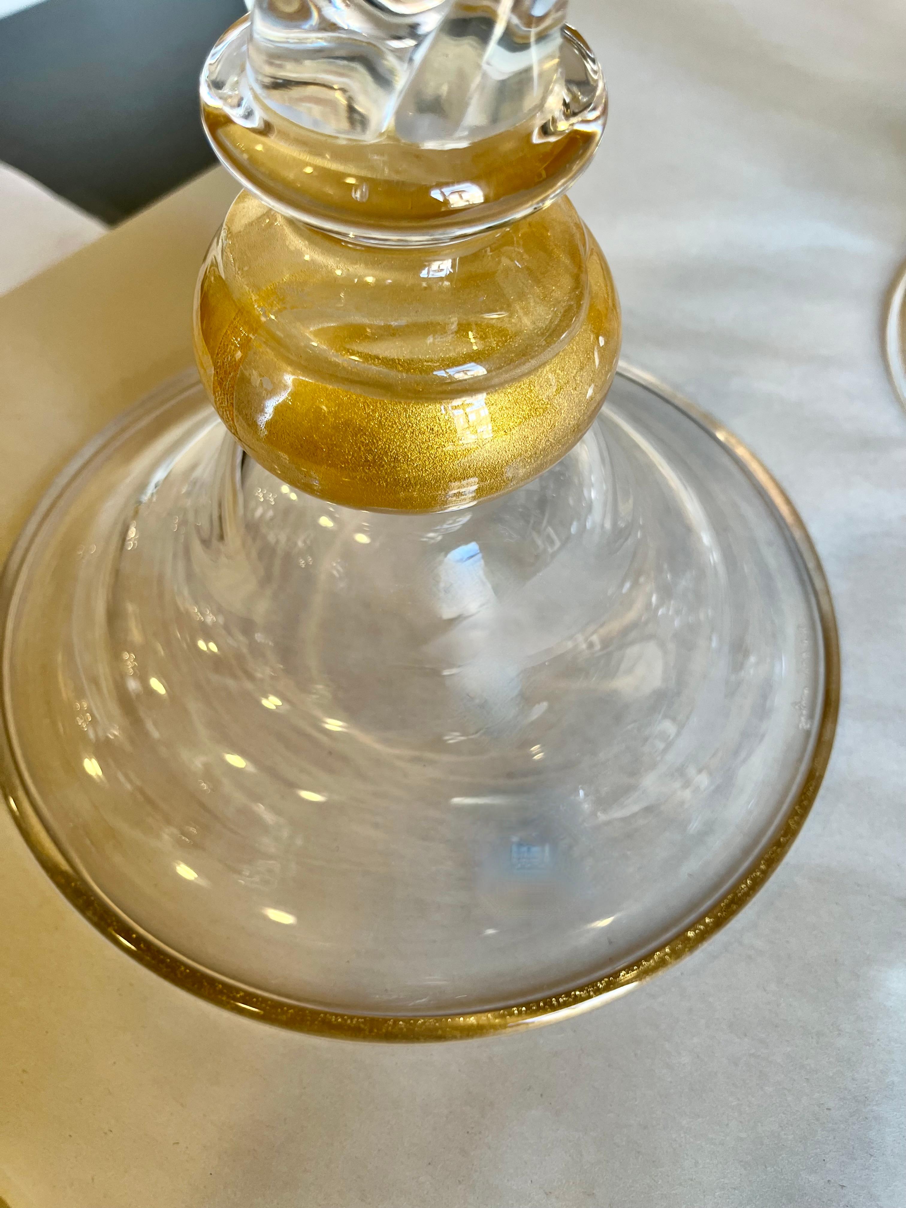 Paire de hauts bougeoirs en verre soufflé de Murano signés sur la base Seguso Vetri d' arte. Les bougeoirs en verre transparent strié en spirale sont ornés d'infusions d'or au sommet et près de la base. 