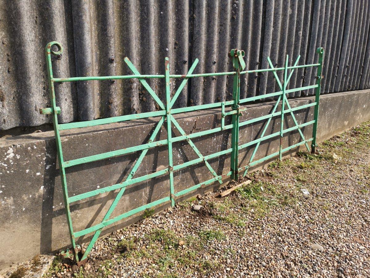 A pair mid Victorian handwrought iron and hand riveted meadow gates with simple scroll details at each upper end, and a simple latch with a swing over clasp to the top.

Measurements:
Actual gates W-99 inches plus 2 inches each side = 103 inches