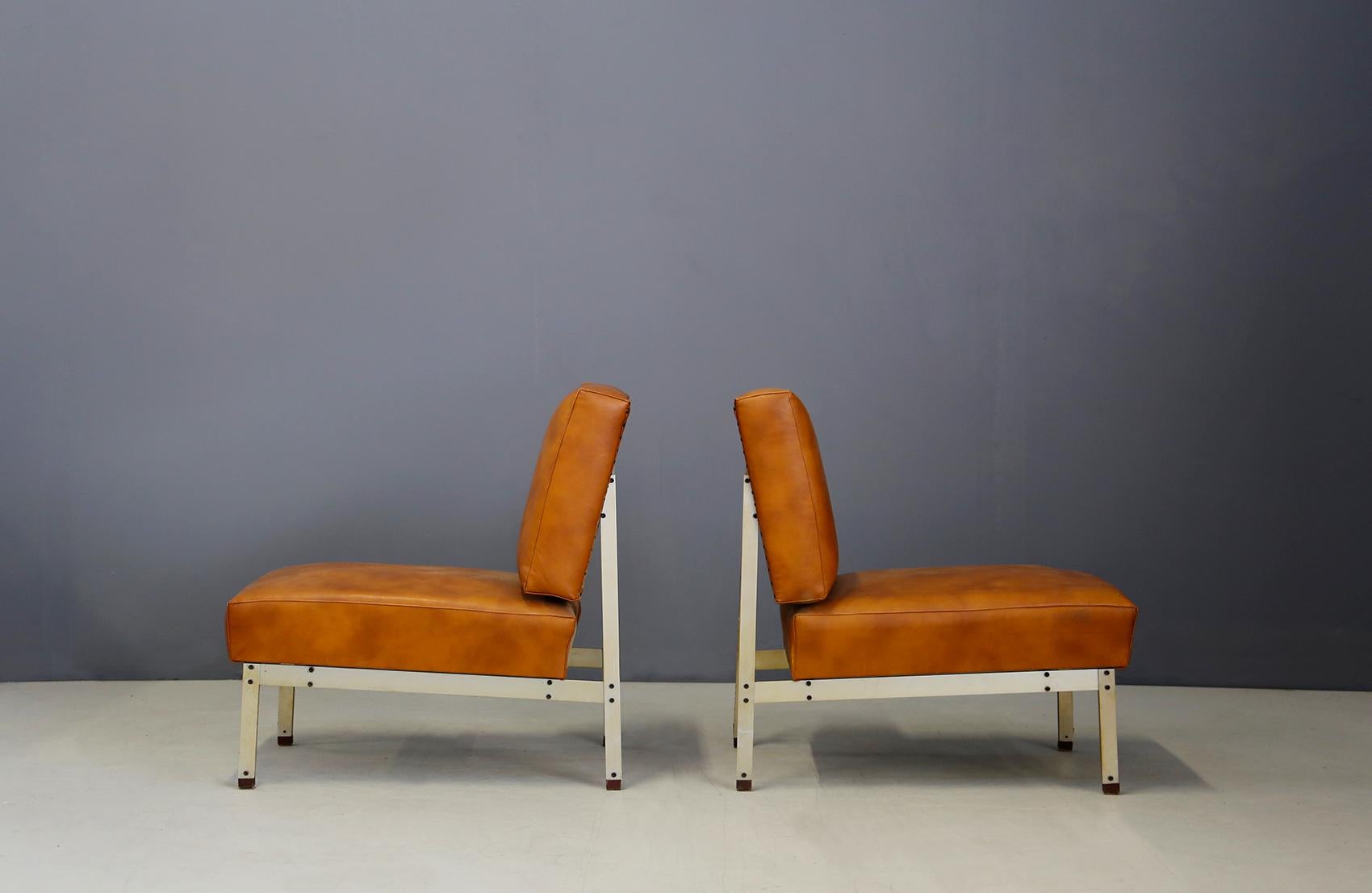 Pair of armchairs in the style of Florence Knoll from 1950. The armchairs have a steel frame inserted in a very linear way with clean and essential lines. Its seat and backrest cover is in light brown leather in perfect condition. In the back of the