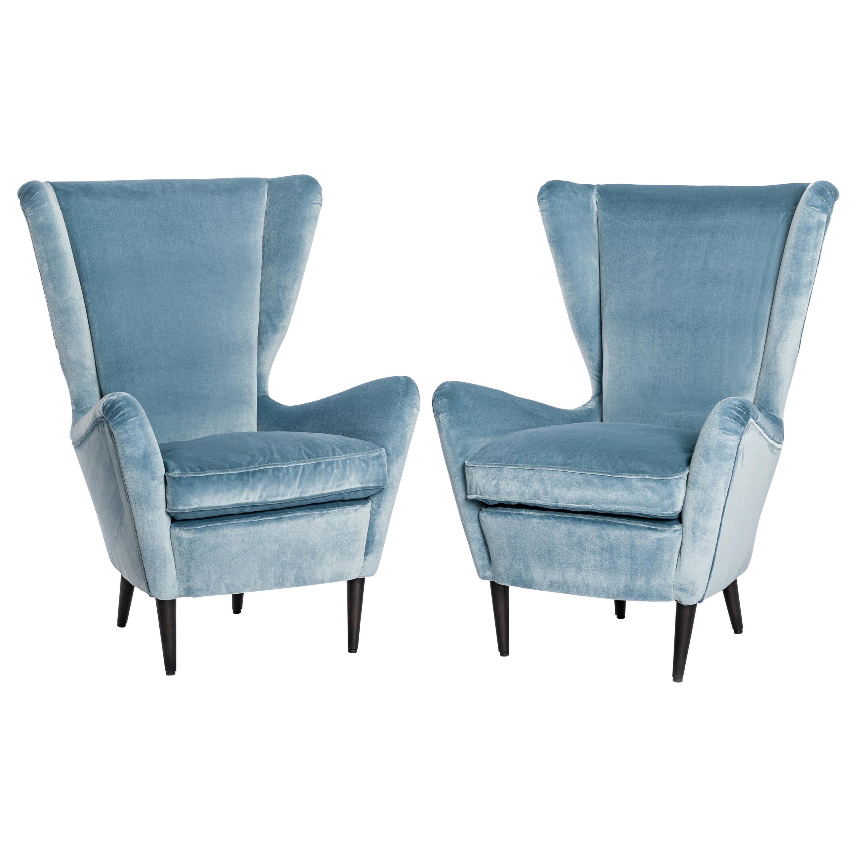 Pair of excentric shaped armchairs by ISA, Bergamo 1950s.
The lovely Italian design language is underlined by the powdery, soft velvet fabric Martora in turquoise-acqua color 
by Rubelli, Venezia.
The seating comfort is very pleasant due to the high