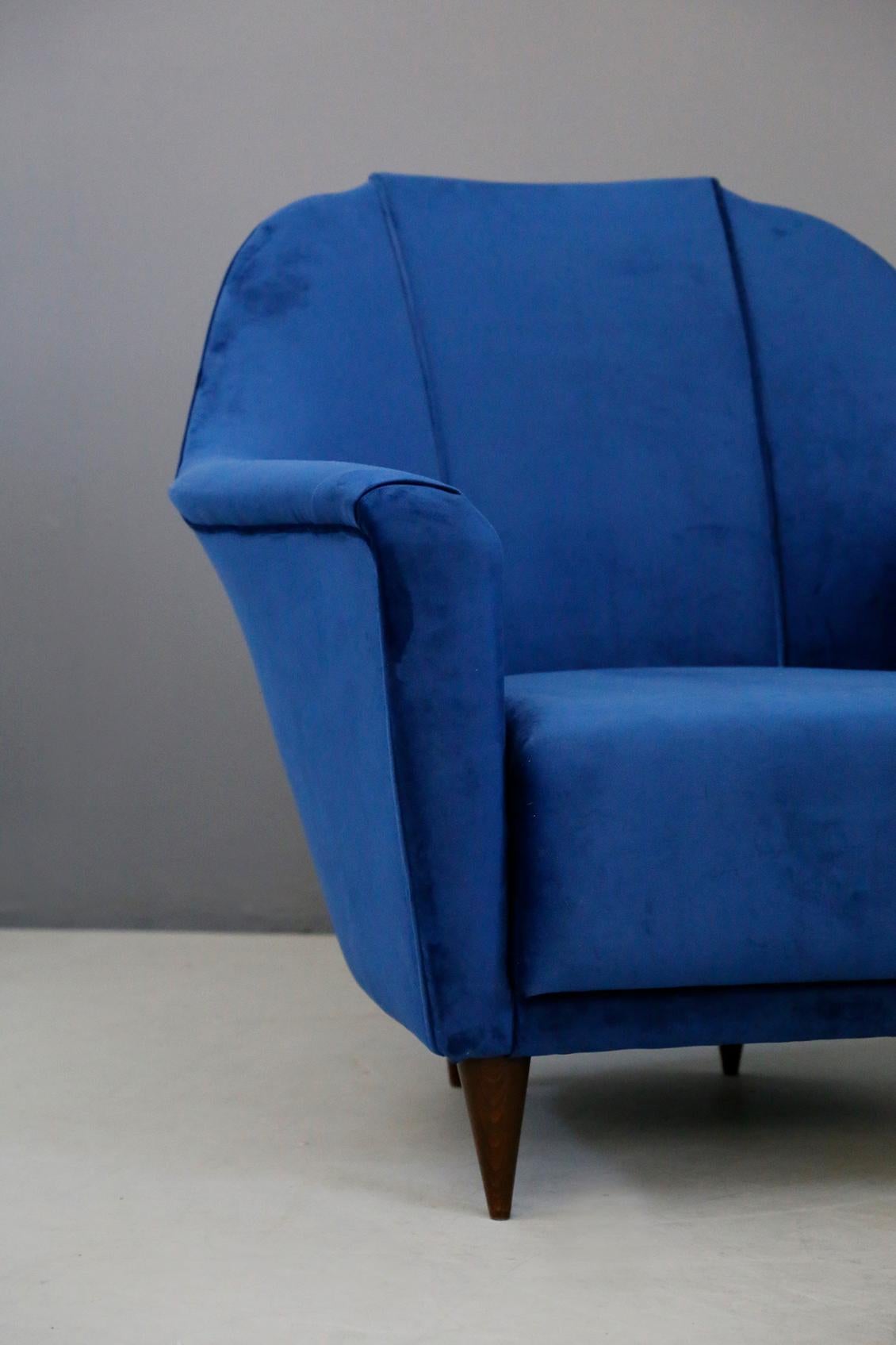 Elegant pair of armchairs by Ico Parisi for Ariberto Colombo Cantu from 1950s. The armchairs have been restored in blue velvet. The feet are conical shaped in walnut wood. Their beautiful shape is ideal for all types of living rooms. The