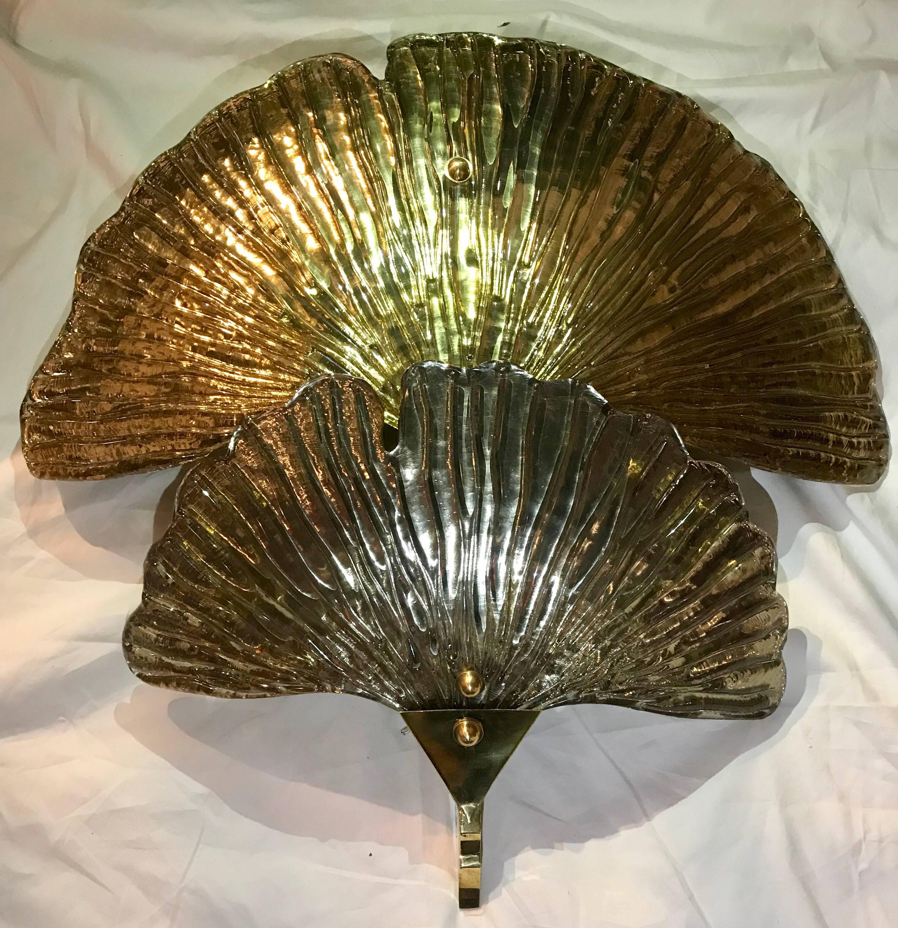 Pair of Murano glass two tier gingko leaf sconces with one silvered gingko leaf, and the other gingko gold leafed, on a brass support. There is a subtle green hue when lit due to the thickness of the natural glass color. A signature was not found