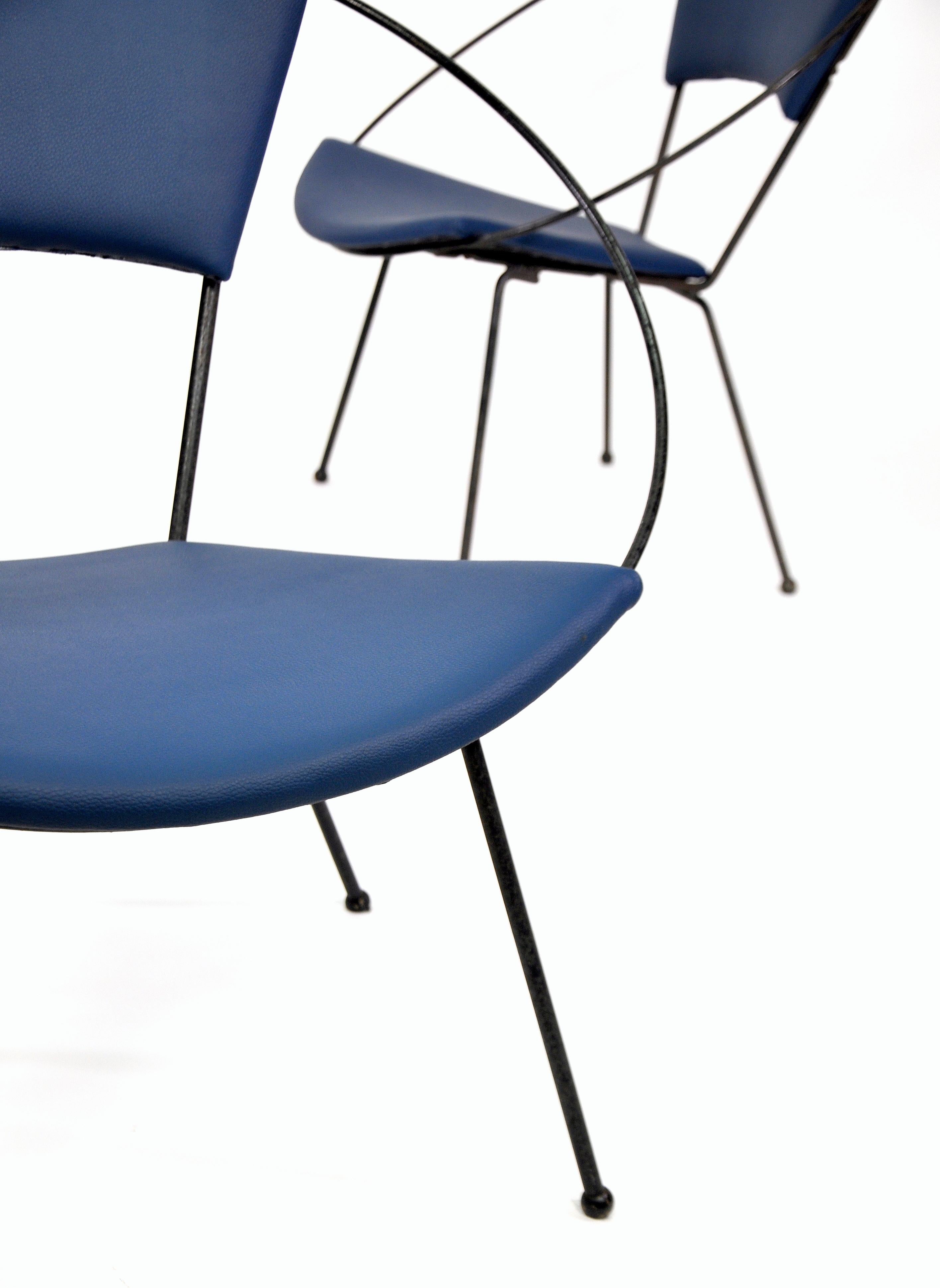 Vintage pair of Mid-Century Modern black wrought iron circle chairs from the 1950s, newly reupholstered in navy blue vinyl. Designed by Joseph Cicchelli for Reilly-Wolff, the armchairs were touted as an innovation in design and comfort at the time.