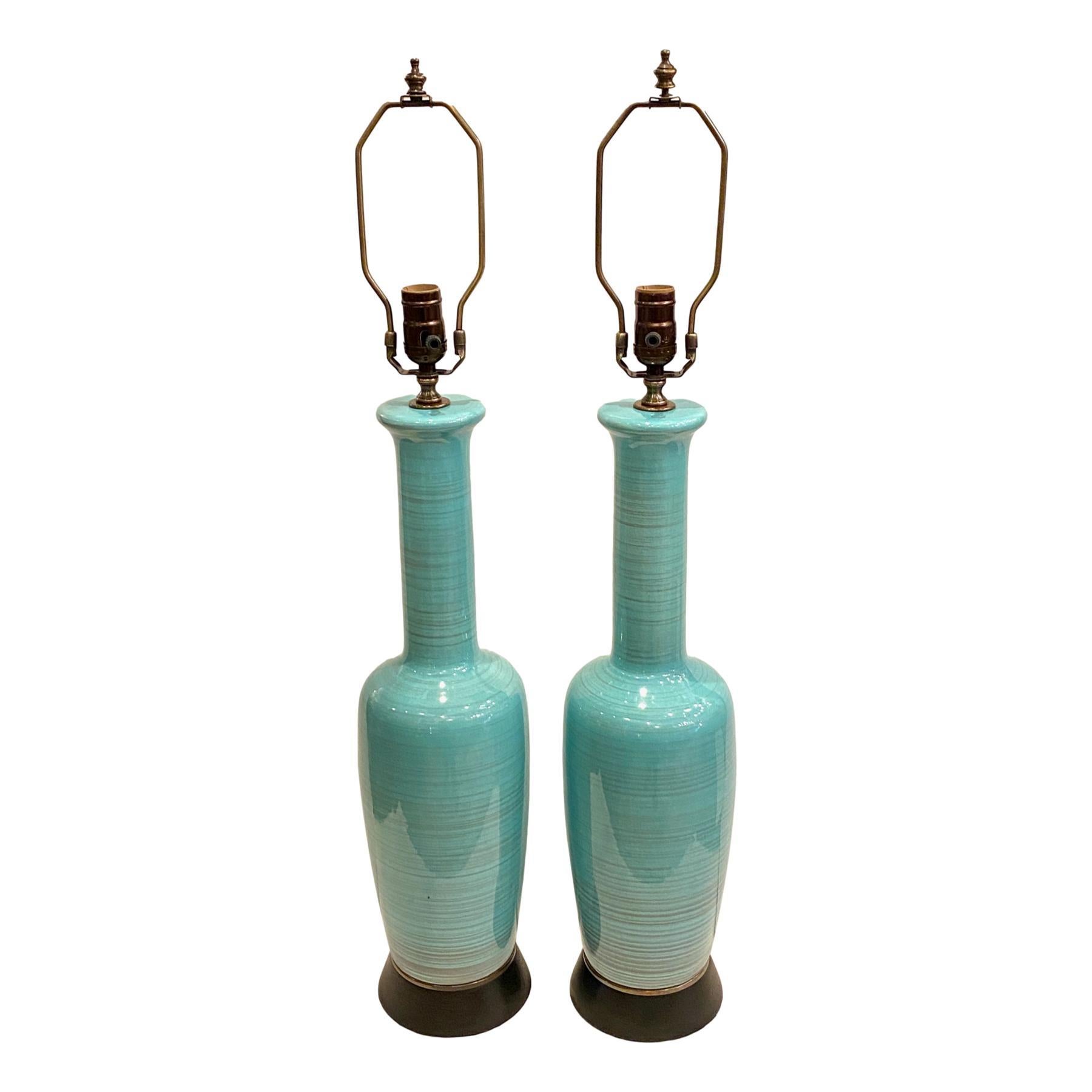 A pair of circa 1960's Italian glazed porcelain table lamps with ebonized bases.

Measurements:
Height of body: 23