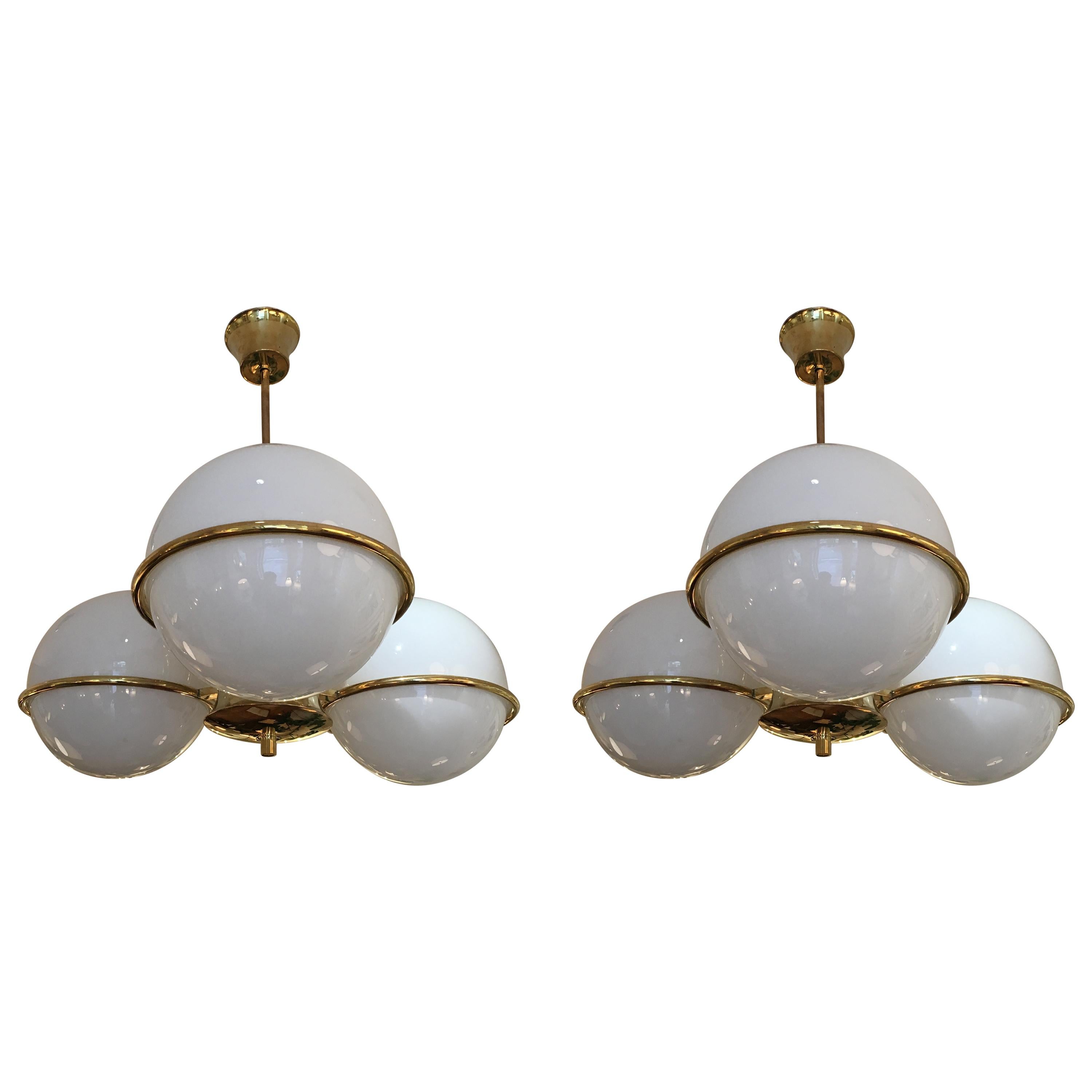 A pair of brass and opaline glass globes three-light chandeliers
Sweden, second half of the 20th century.