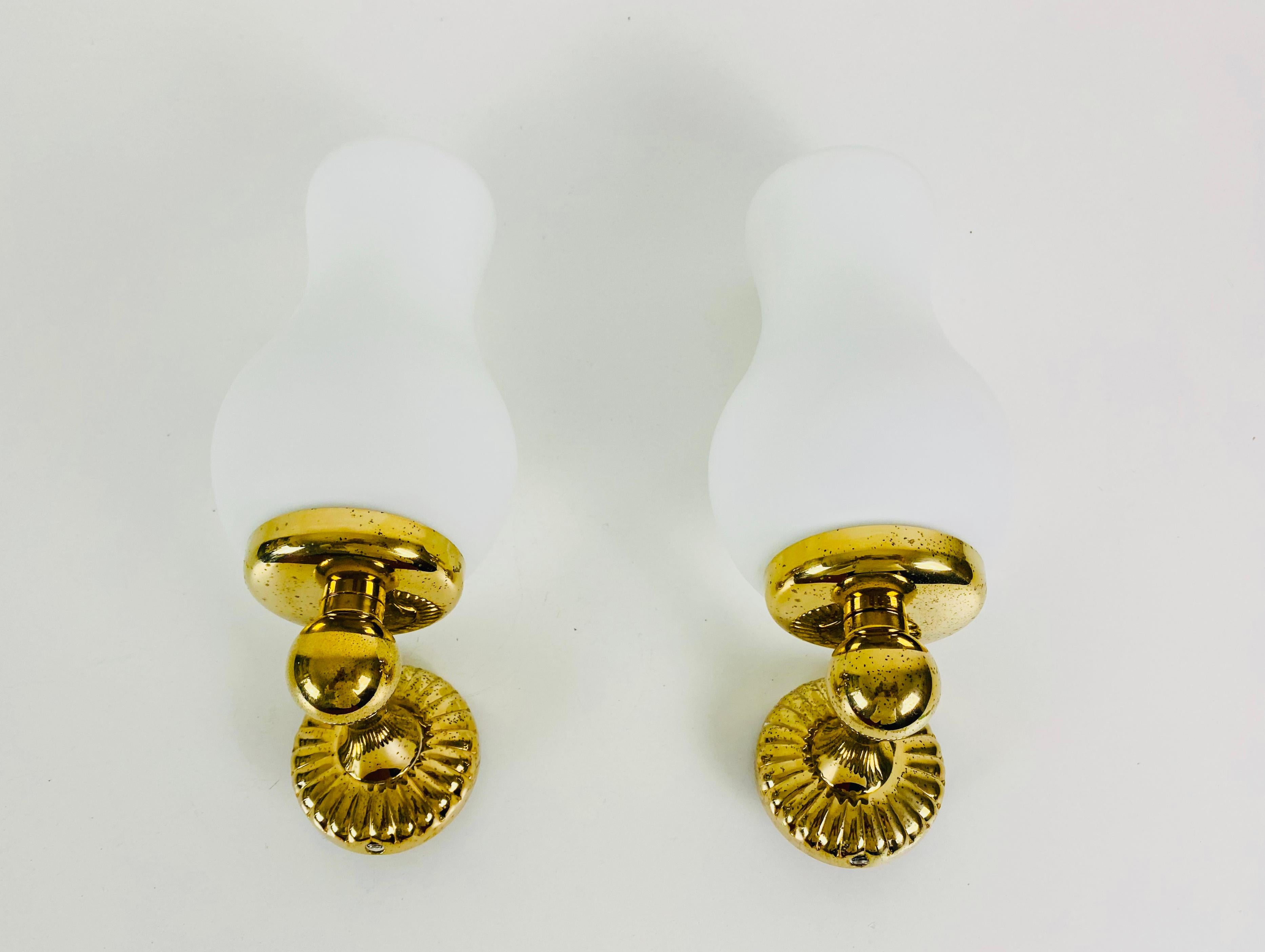 A pair of Italian wall lamps made in the 1960s in the style of Stilnovo. It is fascinating with its rare glass shape. The body of the lamp is made of brass 

The lights require E14 light bulbs. Works with both 120/220V. Very good vintage