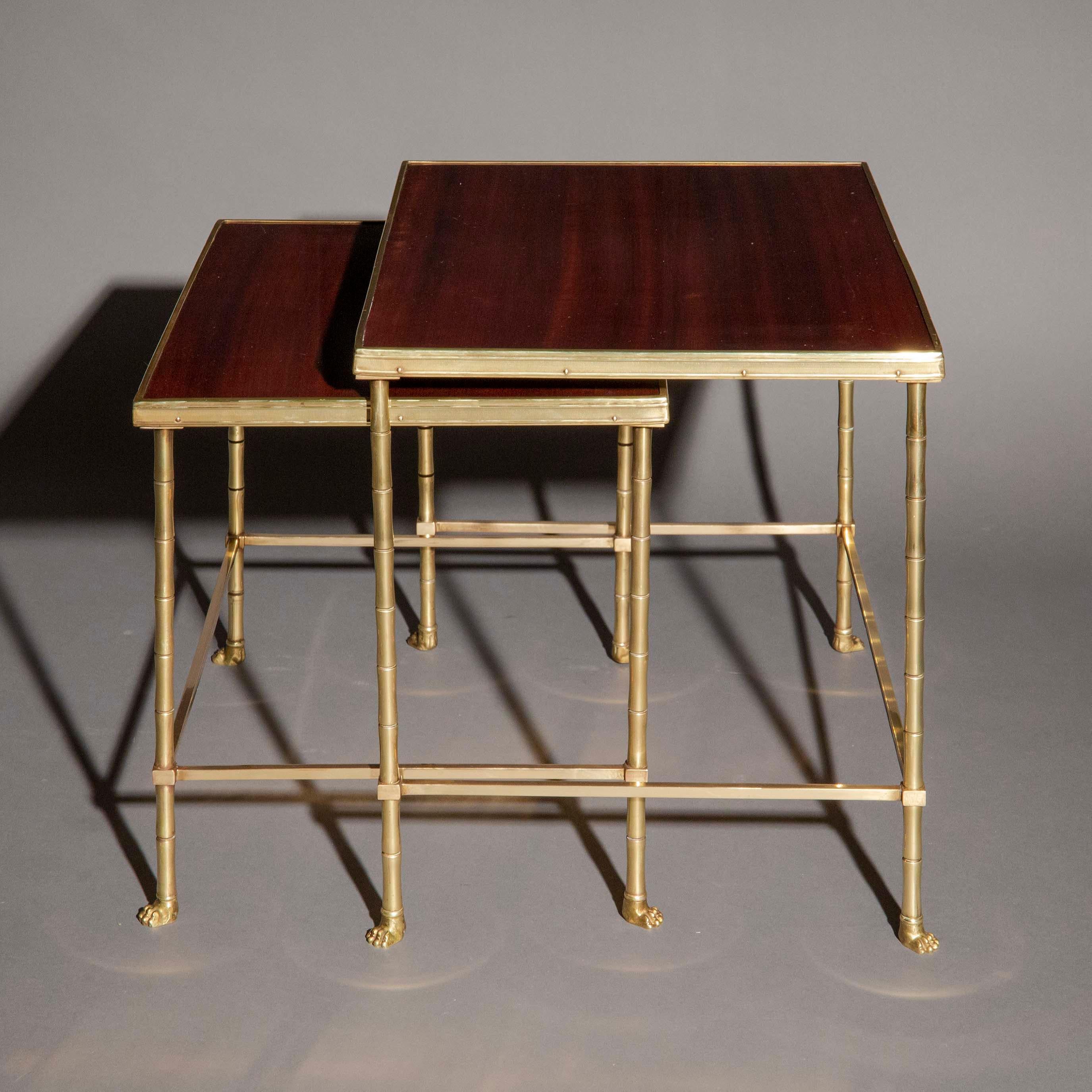 A fine quality graduated pair of low tables or cocktail tables, on faux bamboo brass legs with paw feet and polished veneered tops, in the style of Maison Baguès. France, mid-20th century

Why we like them
Evoking the elegant Directoire-era