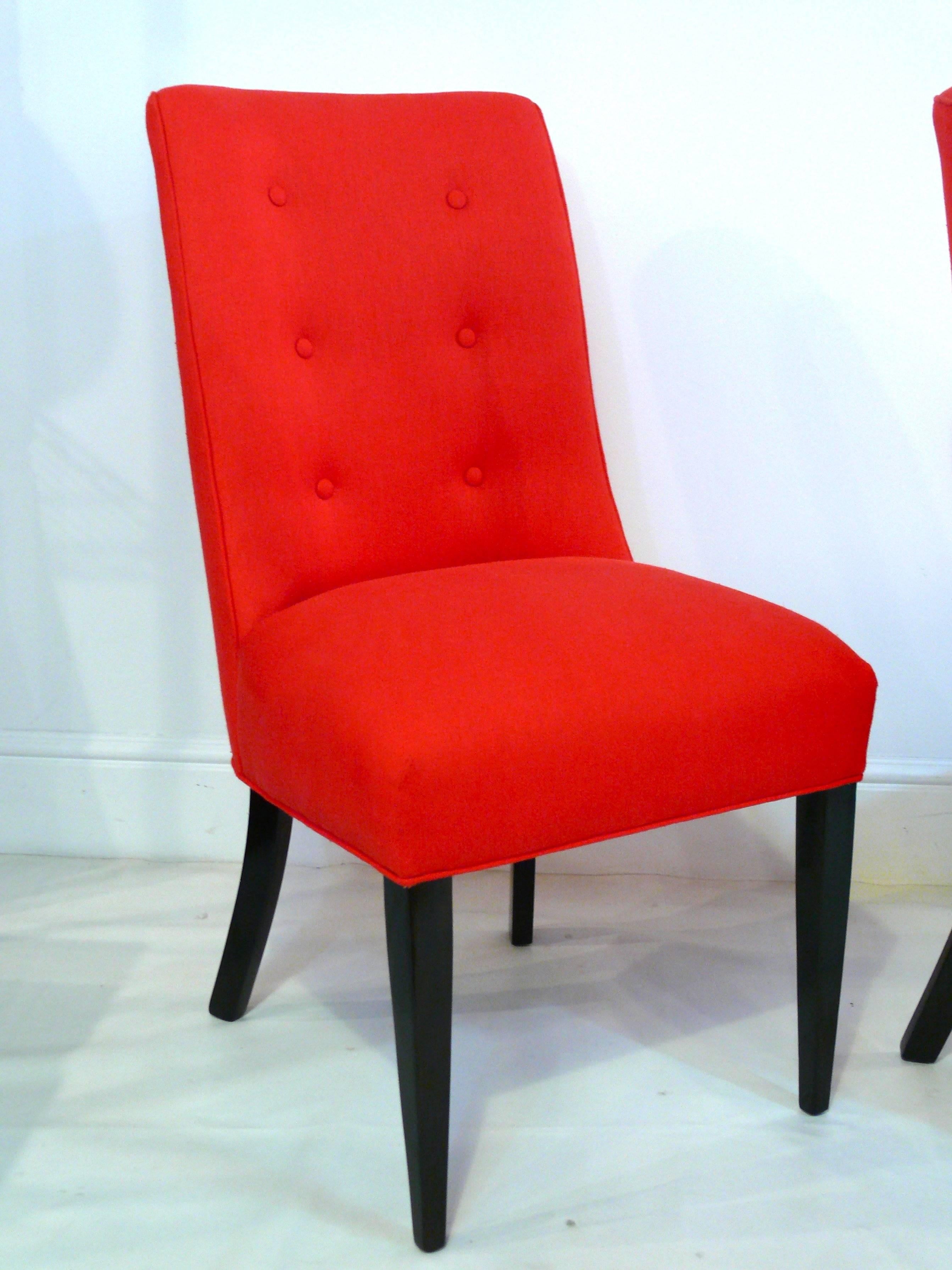Pair of midcentury button back chairs with splayed back legs. Chairs are covered in a nubby poppy red cotton with ebonized legs. They were refinished and reupholstered about 8 years ago and look as they were hardly sat on. Slight wear on legs