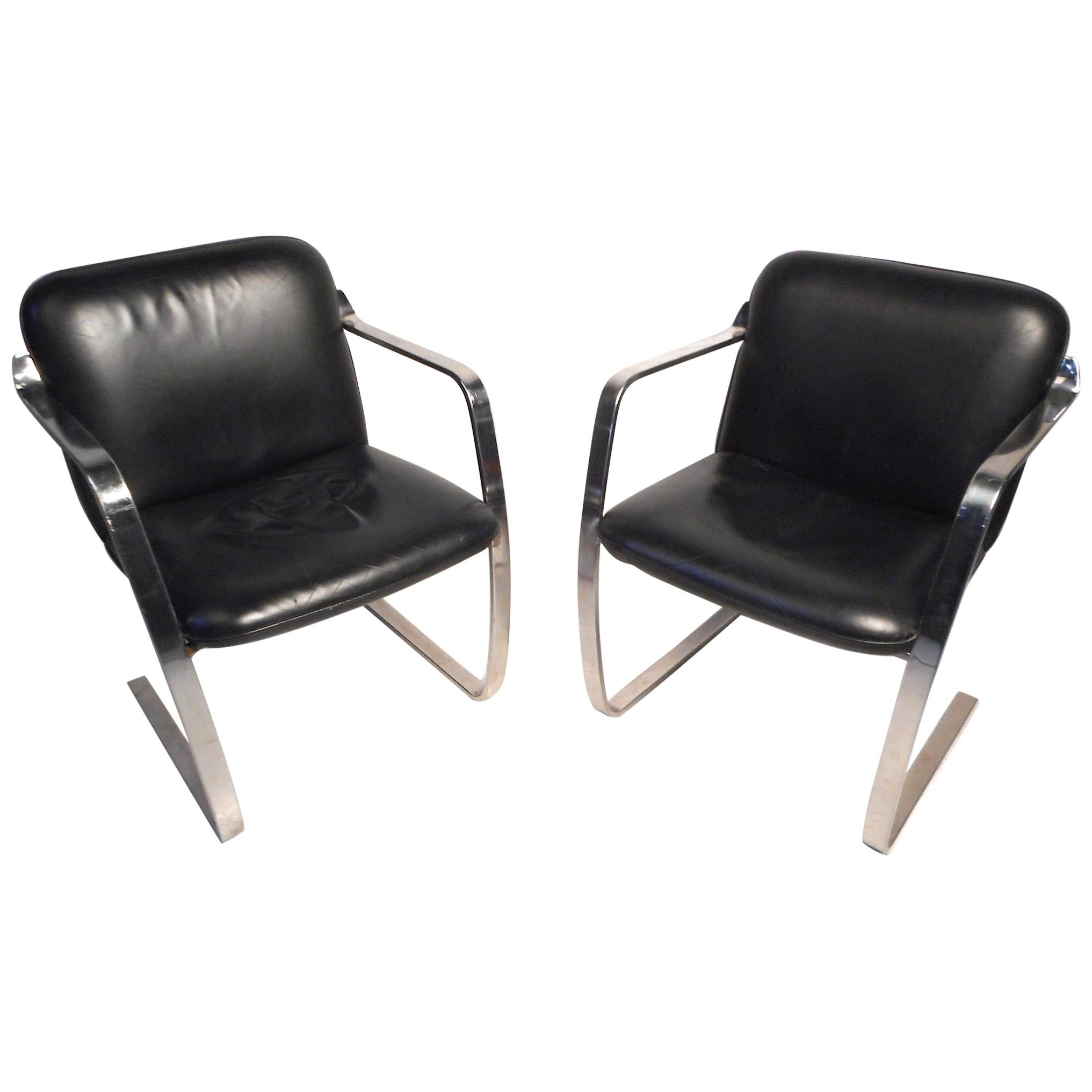 Cette élégante paire de chaises du milieu du siècle présente un élégant rembourrage en simili-cuir noir et des cadres cantilever robustes en métal. Conçues d'après les célèbres chaises Brno de Knoll, ces chaises sont un ajout parfait à l'intérieur