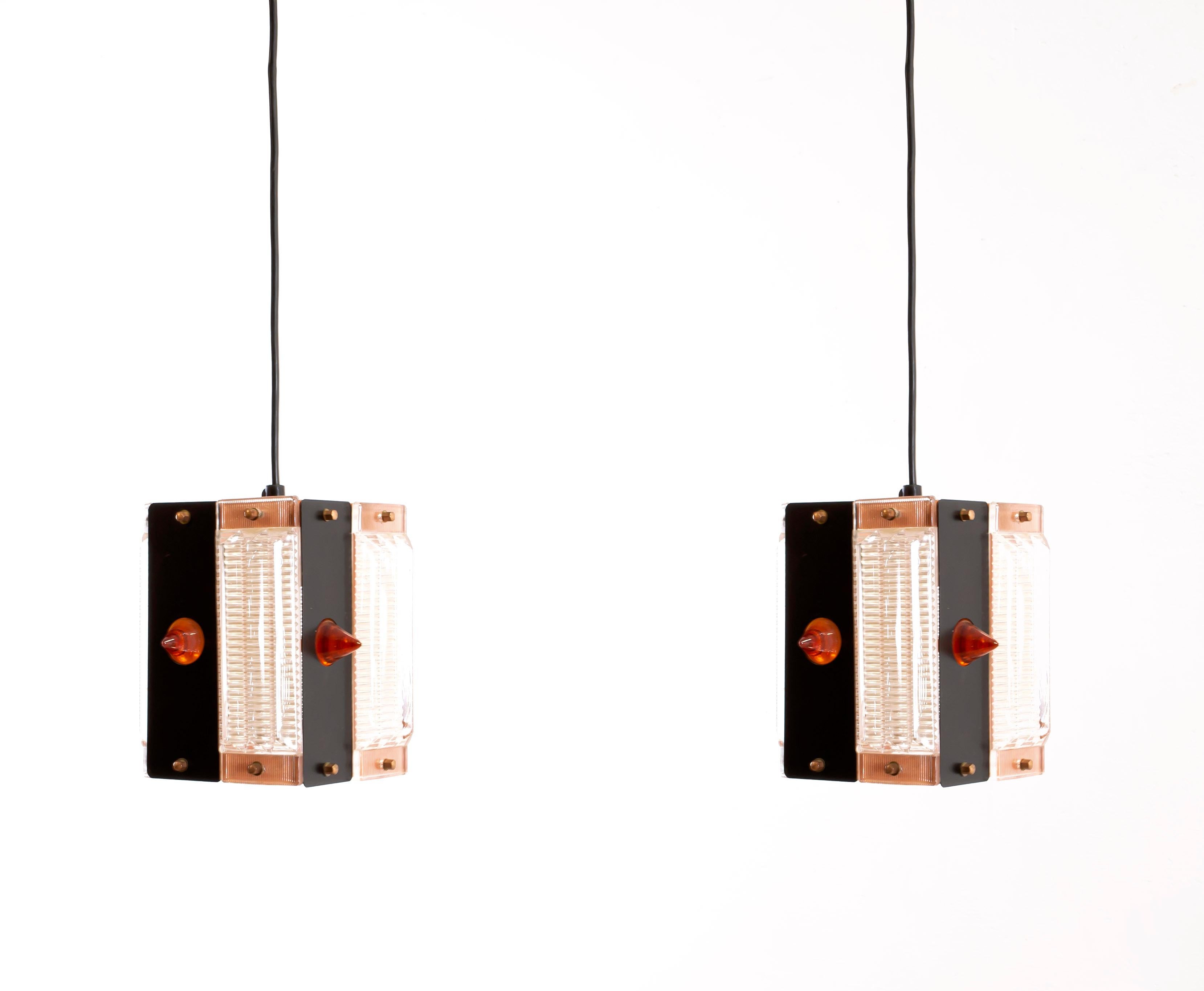Decorative and rare pendants in painted steel, copper, and glass. Designed and made in Norway from circa 1960s second half. Both lamps are fully working and in very good vintage condition. Each lamp is fitted with an E27 bulb holder (works in the