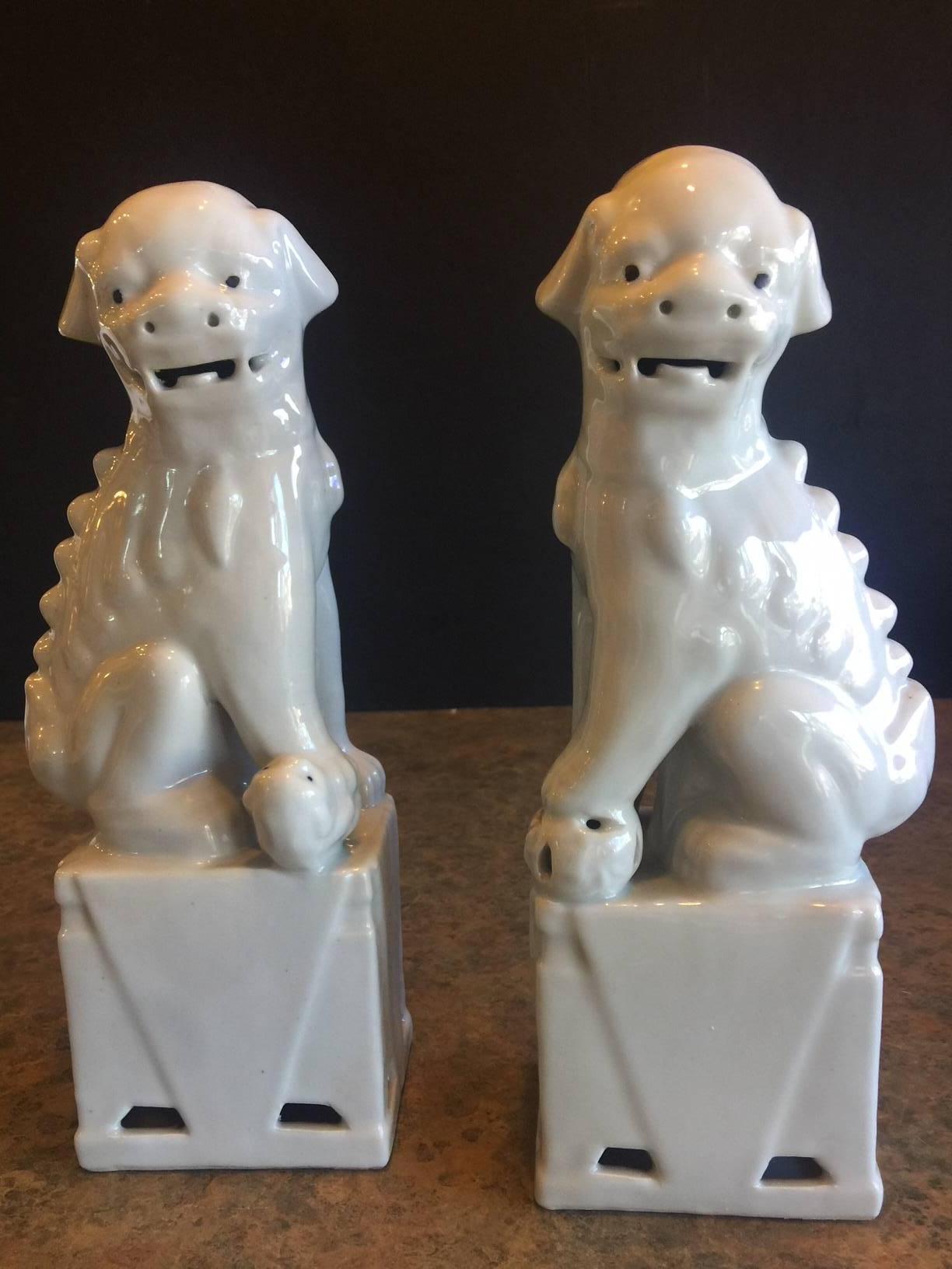 A very nice pair of Chinese, white, ceramic foo dogs, circa 1960s. Excellent condition and patina; makes a great pair of book ends or a fun decor item in any room!