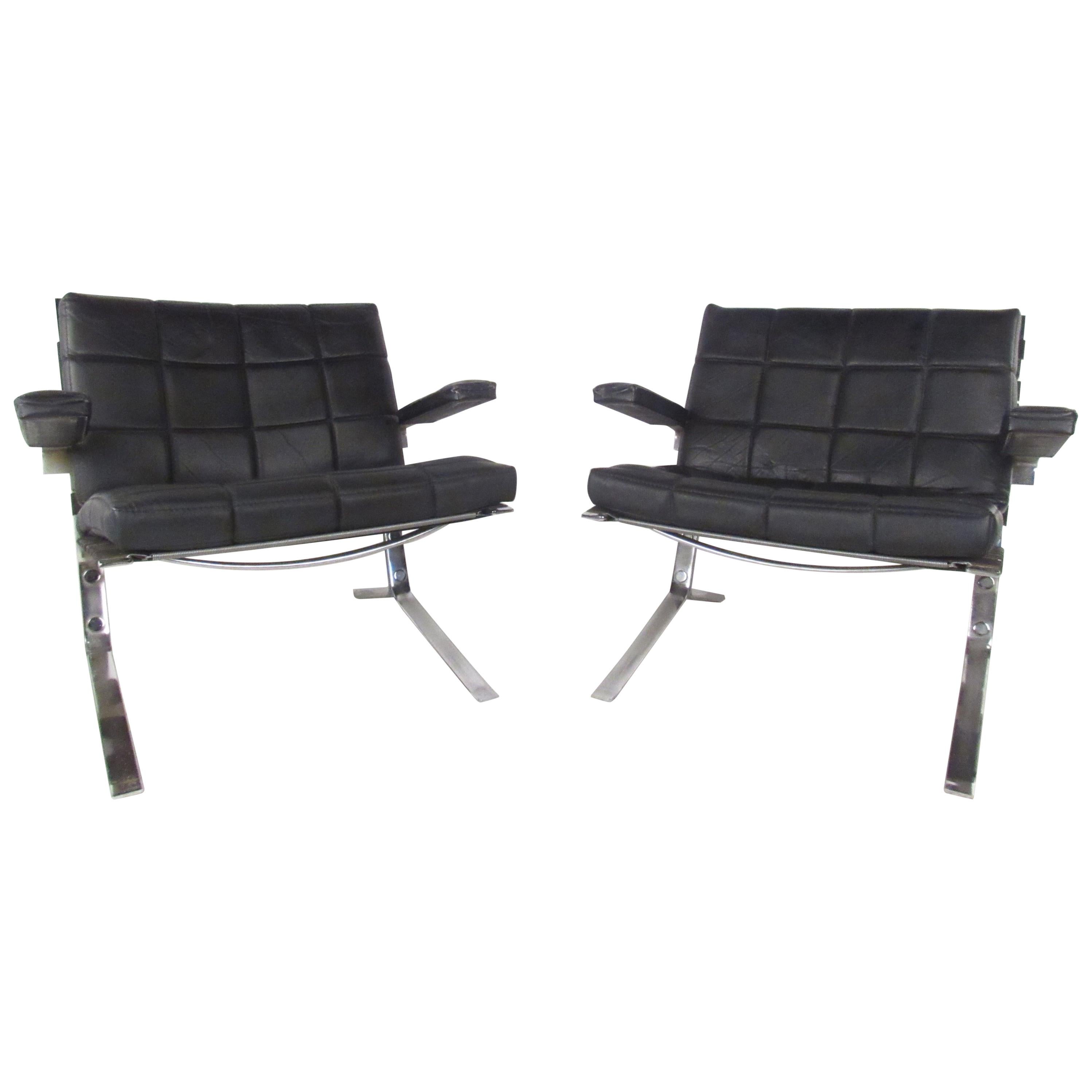 A sleek Danish cantilever design with a heavy chrome base and an overstuffed leather cushion. This unique vintage modern pair of lounge chairs boast thick padded arm rests ensuring maximum comfort in any seating arrangement. Please confirm item