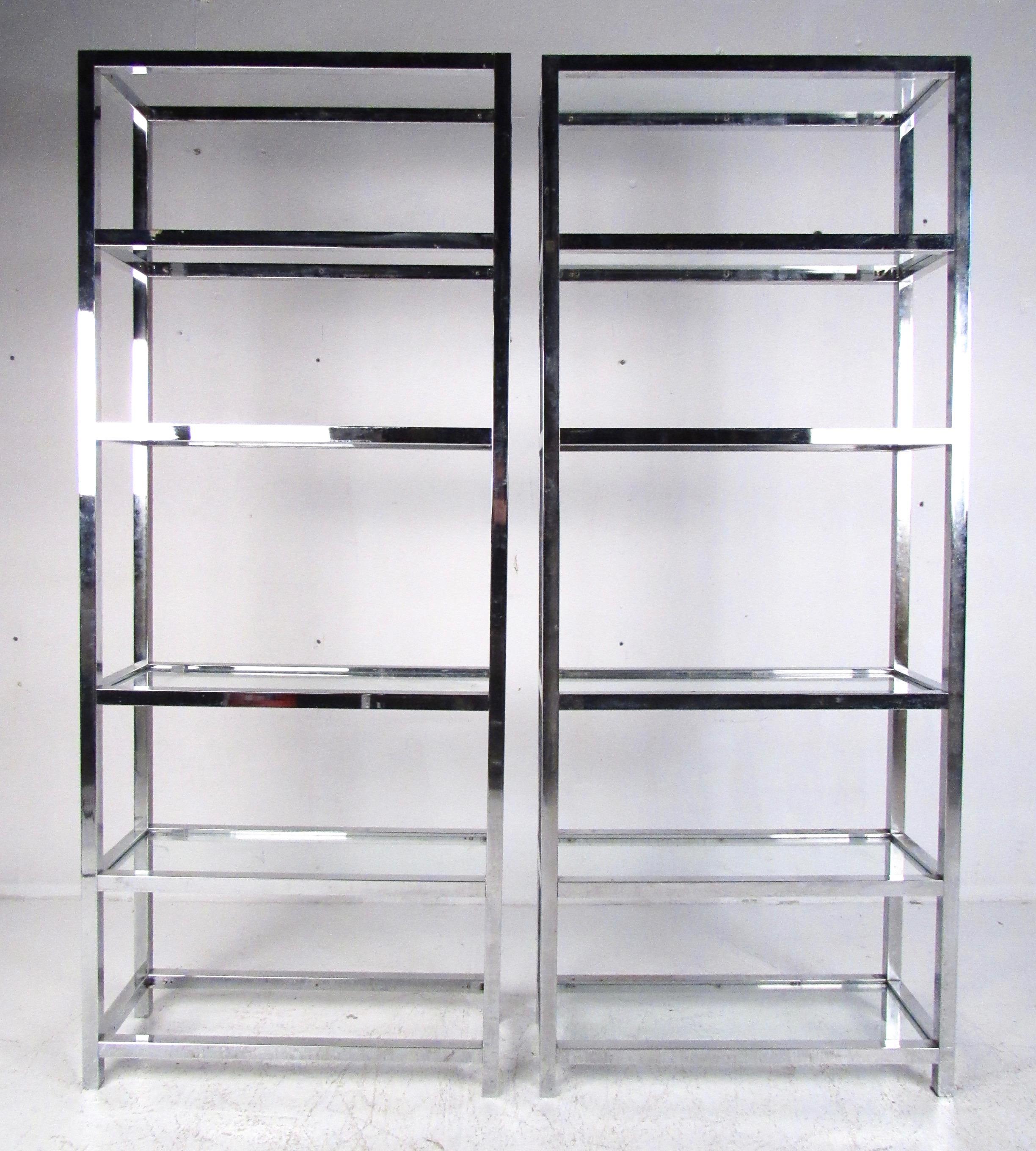 This stylish pair of vintage modern display shelves make a striking Mid-Century Modern addition to home or business display. Each unit has five glass shelves for storage or display set in heavy chrome finish frame. Please confirm item location (NY