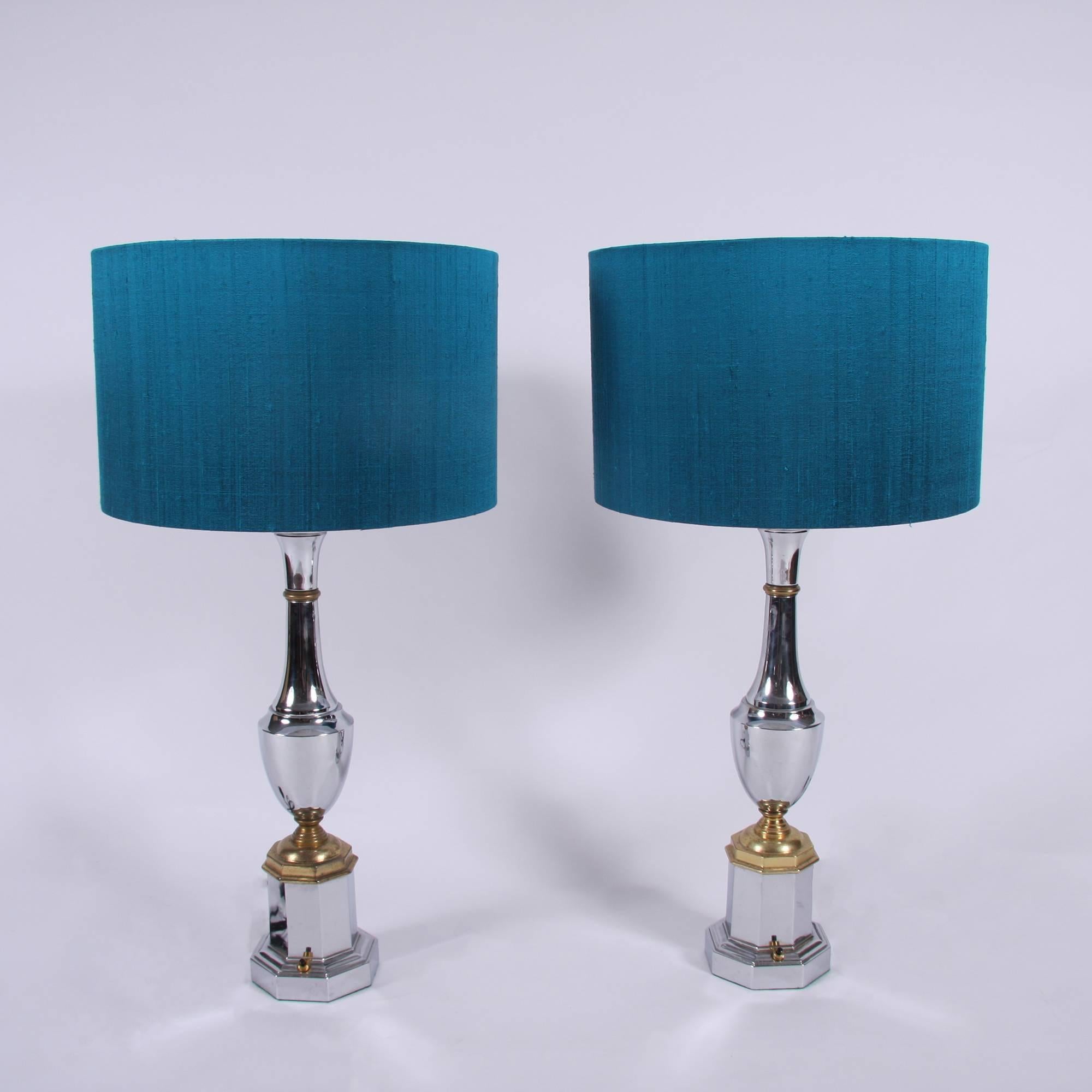 A beautiful pair of French, midcentury, chrome lamps with brass detailing in an urn and plinth shape.

Some patina to the brass sections. With blue silk handmade shades.

Re-wired and PAT tested.

    