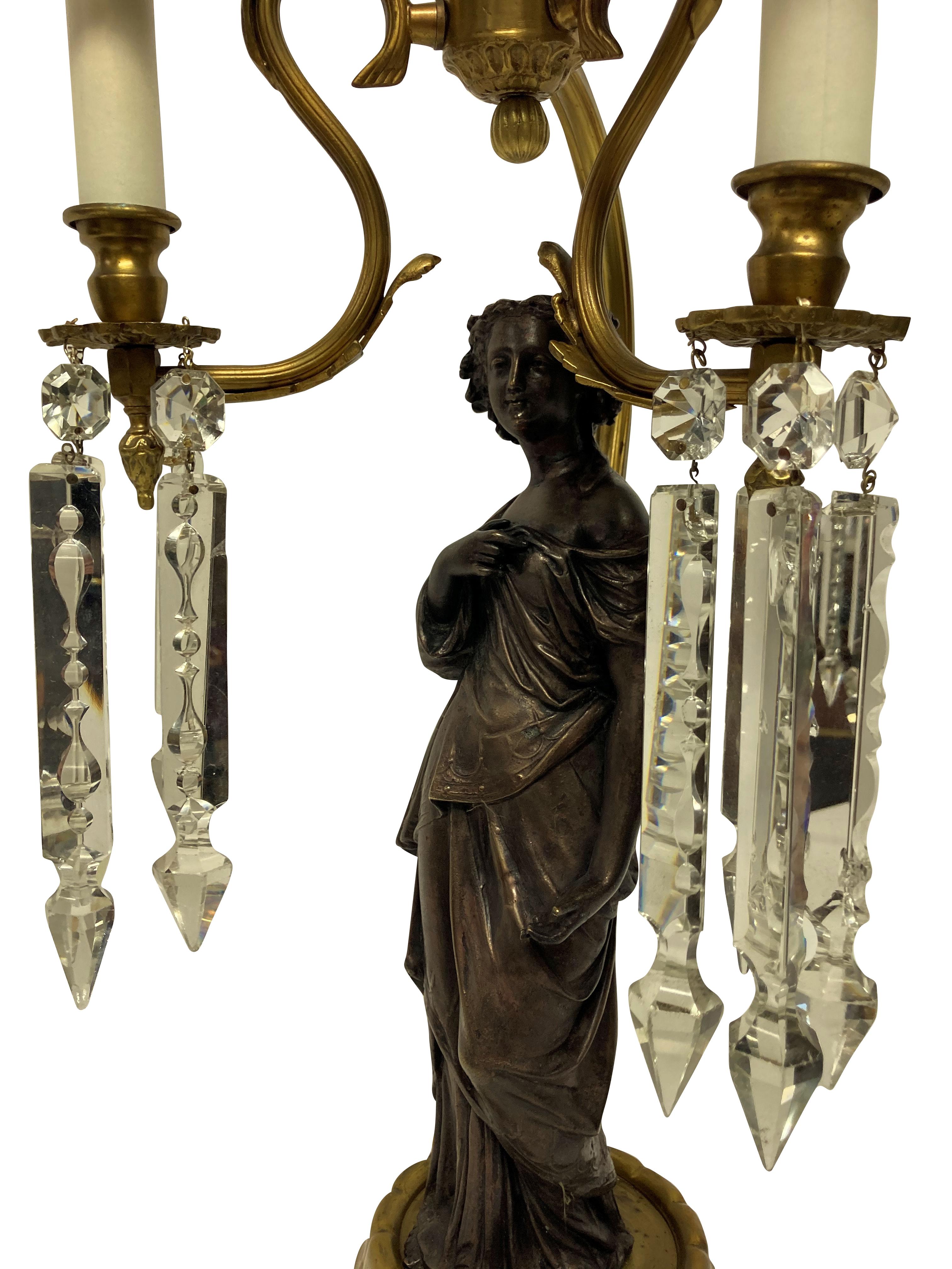 Une paire de lampes classiques italiennes représentant une femme en robe romaine, chacune avec des pendentifs en verre taillé et des abat-jour en soie bleu pâle.