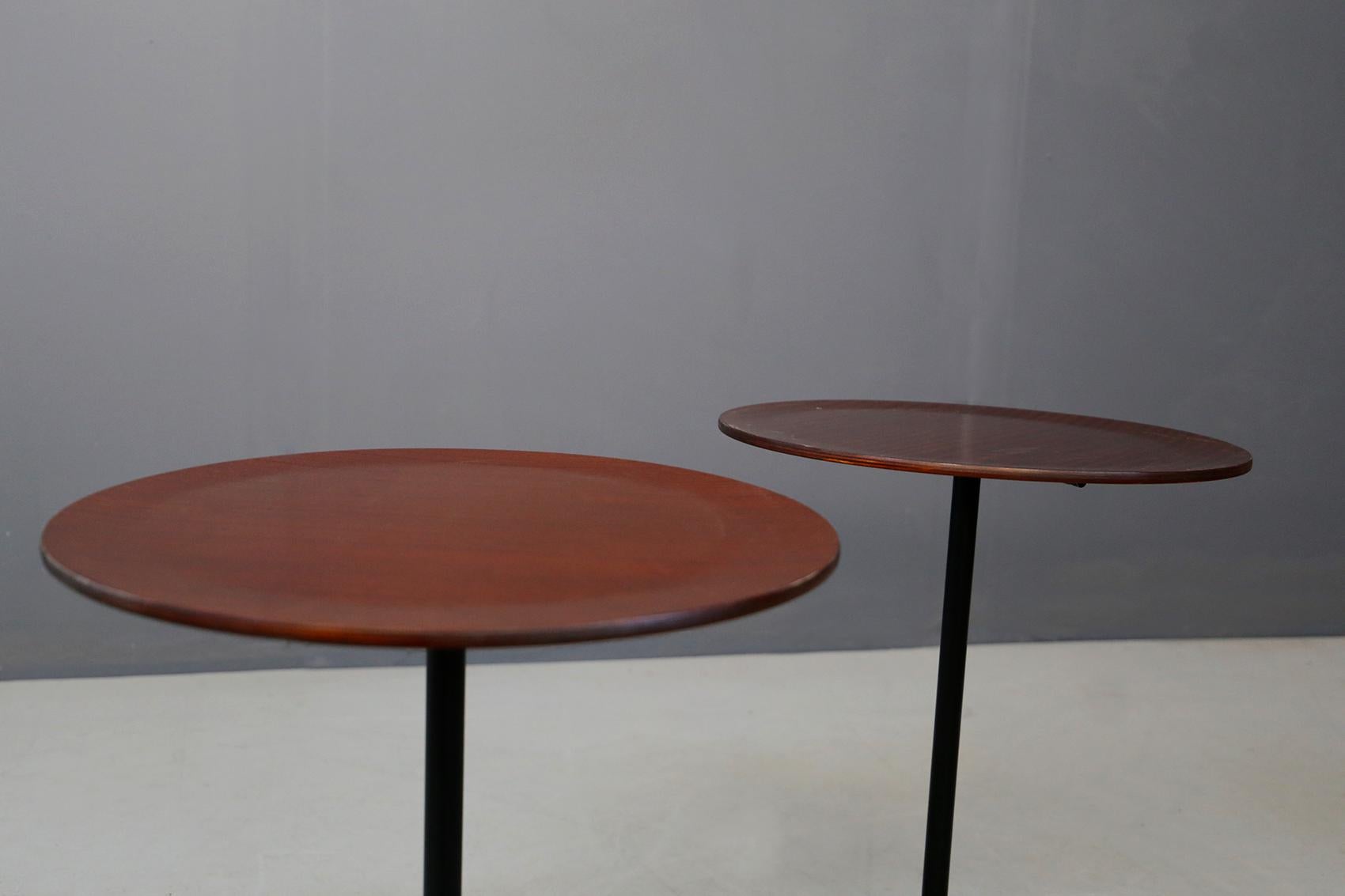 Pair of tables by Osvaldo Borsani for Tecno Model 744. The seat is in mahogany lacquered curved plywood on a painted iron tripod base that ends with brass feet. The pair of coffee tables is ideal on the sides of sofas or to complete design living