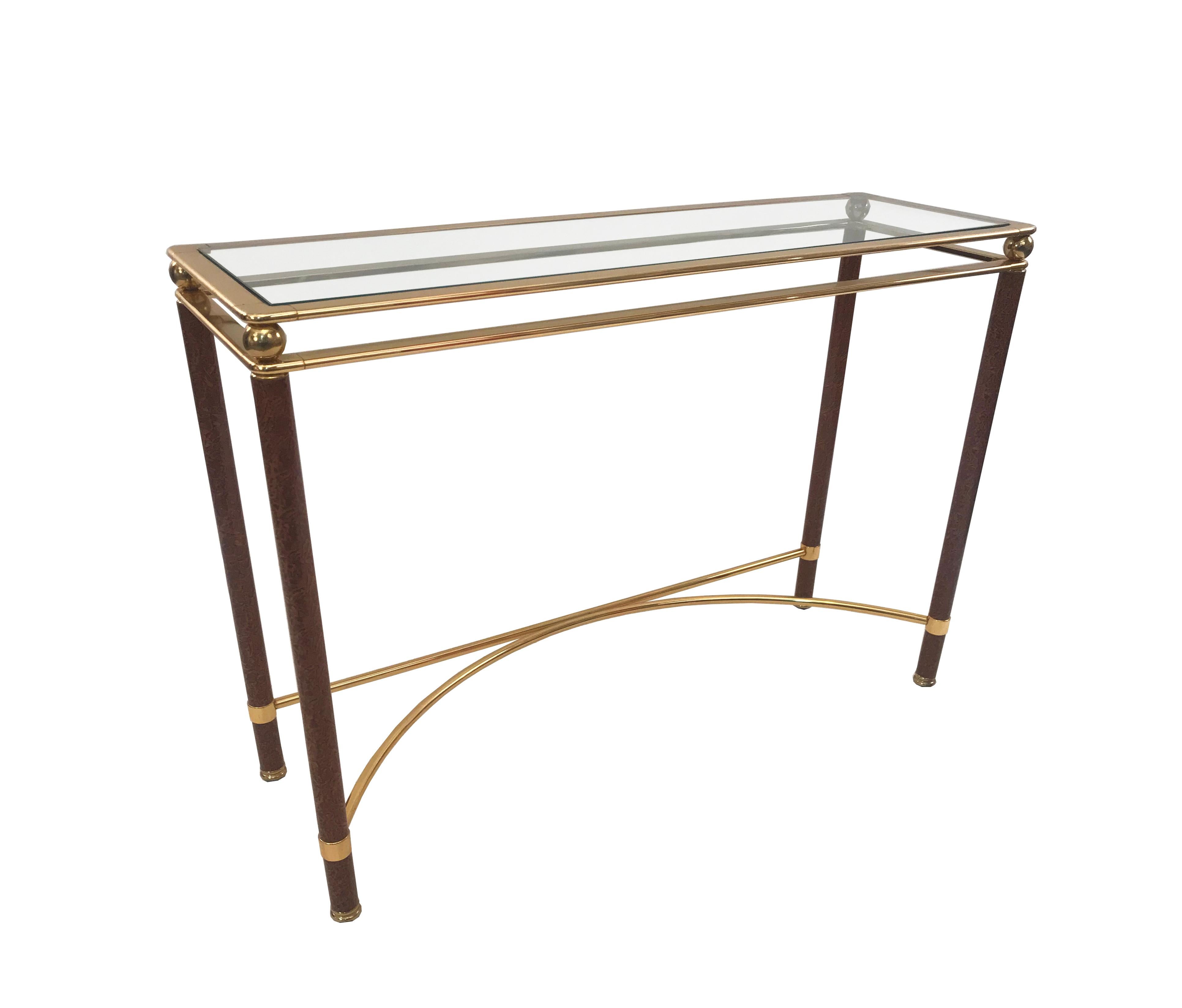 Pair of midcentury console tables with faux tortoise shell legs, brass stretchers and frames, and glass table tops.