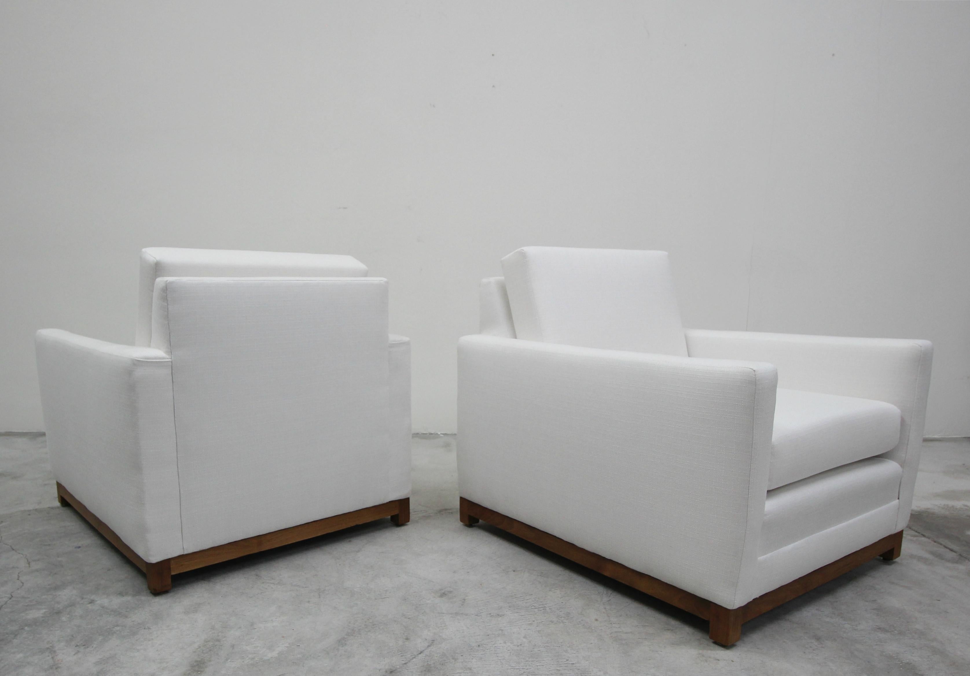 This is a beautifully uncomplex pair of midcentury cube style chairs upon solid teak bases. The simplicity of these chairs would make them a perfect addition to any Minimalist decor.

The chairs have been professionally reupholstered. The frames