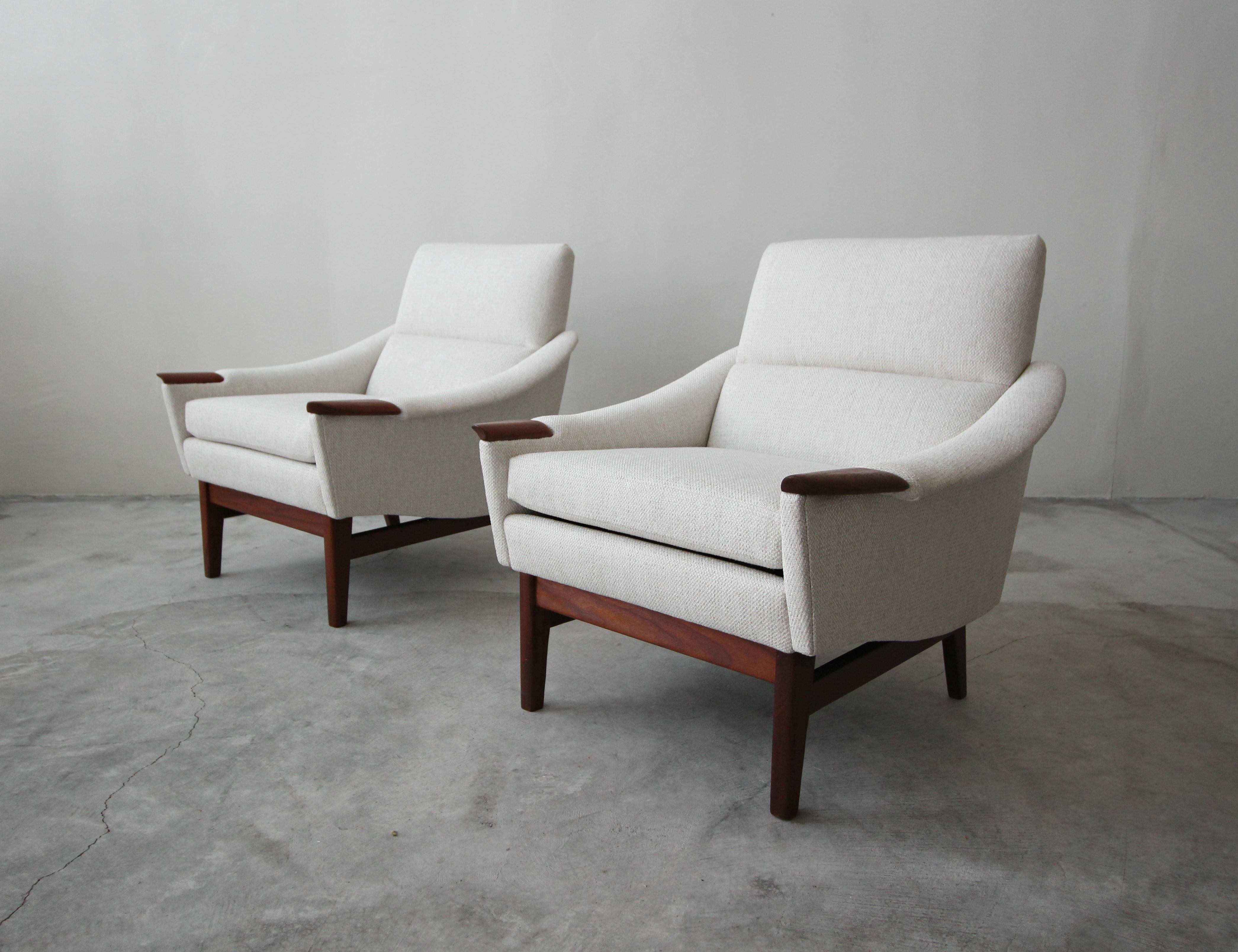 Beautiful pair of Danish Mid-Century Modern lounge chairs. They are the epitome of Classic Mid-Century Modern chairs, with their gorgeous lines and details like their walnut arms.

The chairs have been completely restored with all new foam and