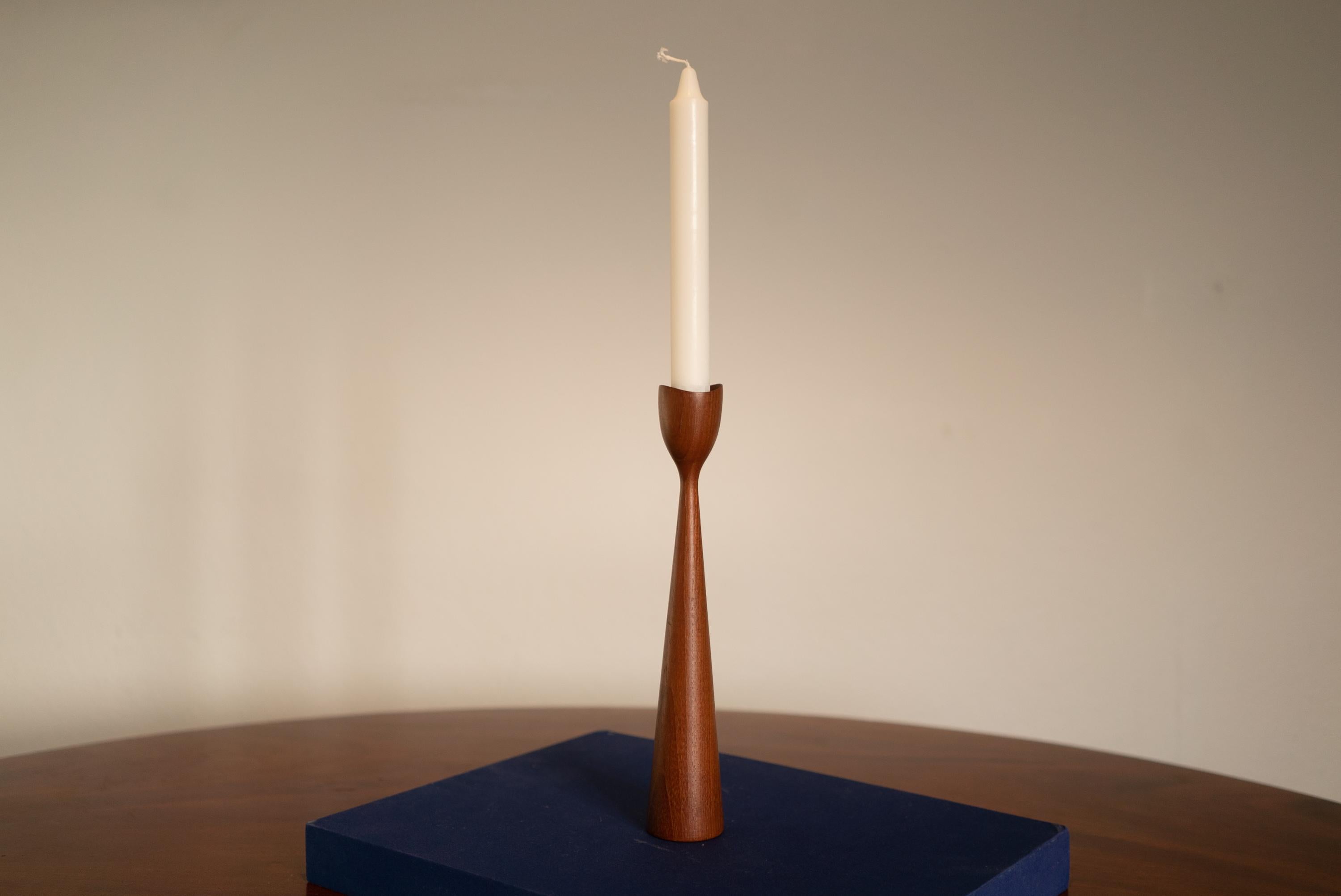 Pair of midcentury Danish teak candlesticks featuring an elegant modern design in a medium brown finish. Denmark 1960s.

Excellent vintage condition, minor scuffs, no damage, no restoration, signs of age and use.

I'm also selling a bit shorter one.