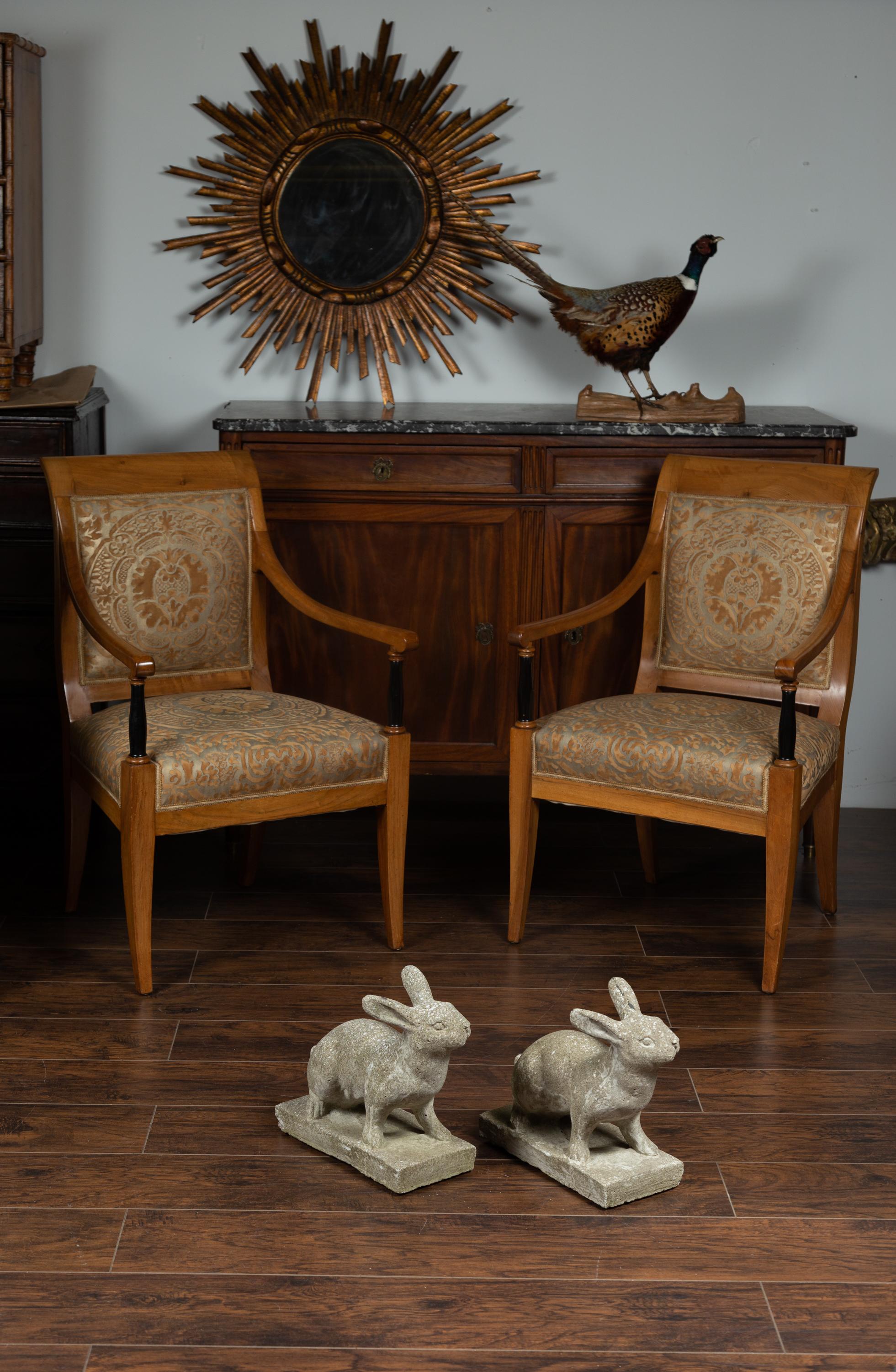 A pair of vintage English concrete rabbit sculptures from the mid-20th century on rectangular bases. Born in England during the midcentury period, this pair of concrete sculptures charms us with its lovely subject and nicely weathered appearances.