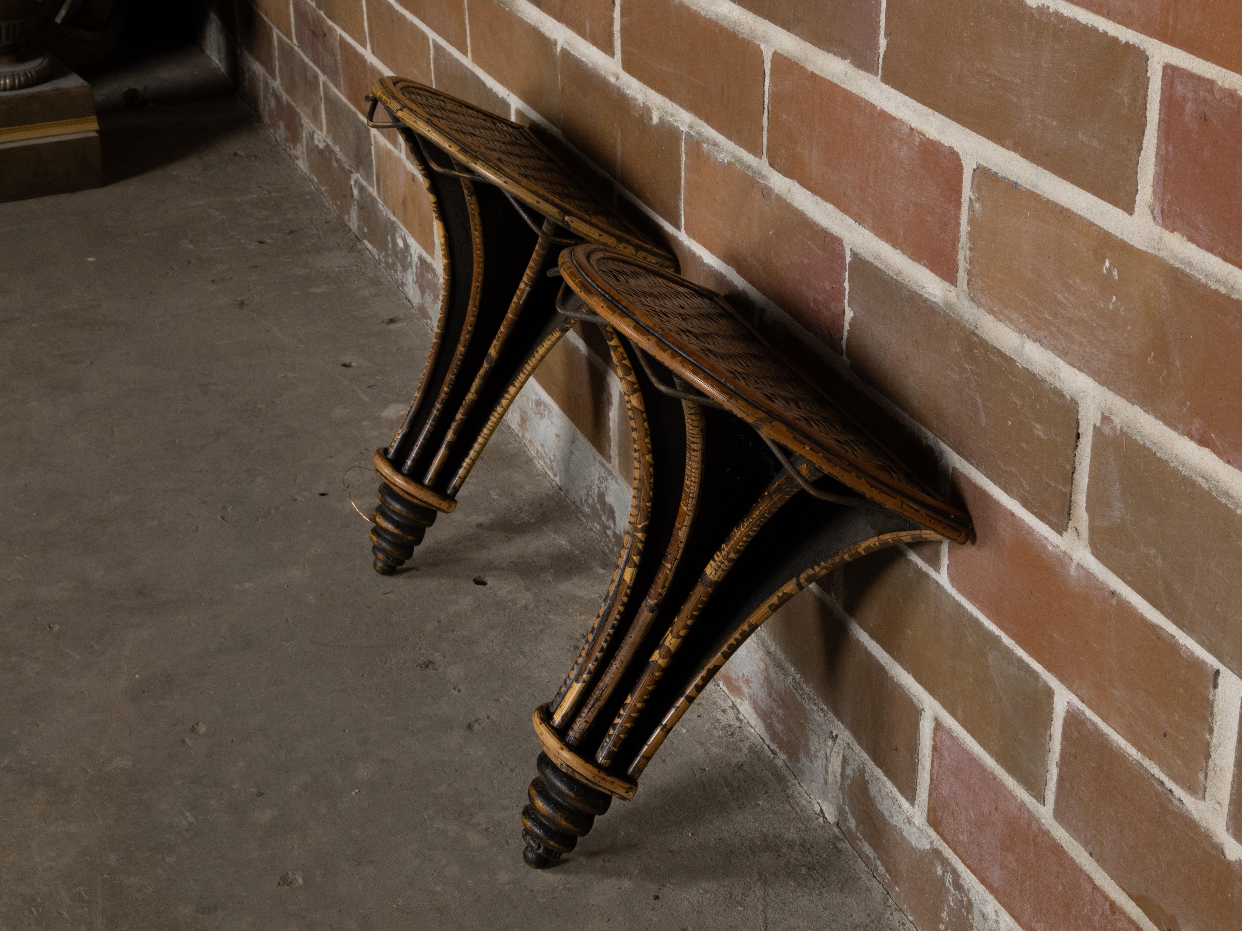 Pareja de soportes de pared ingleses de mediados de siglo de madera ebonizada, bambú y ratán siglo XX en venta