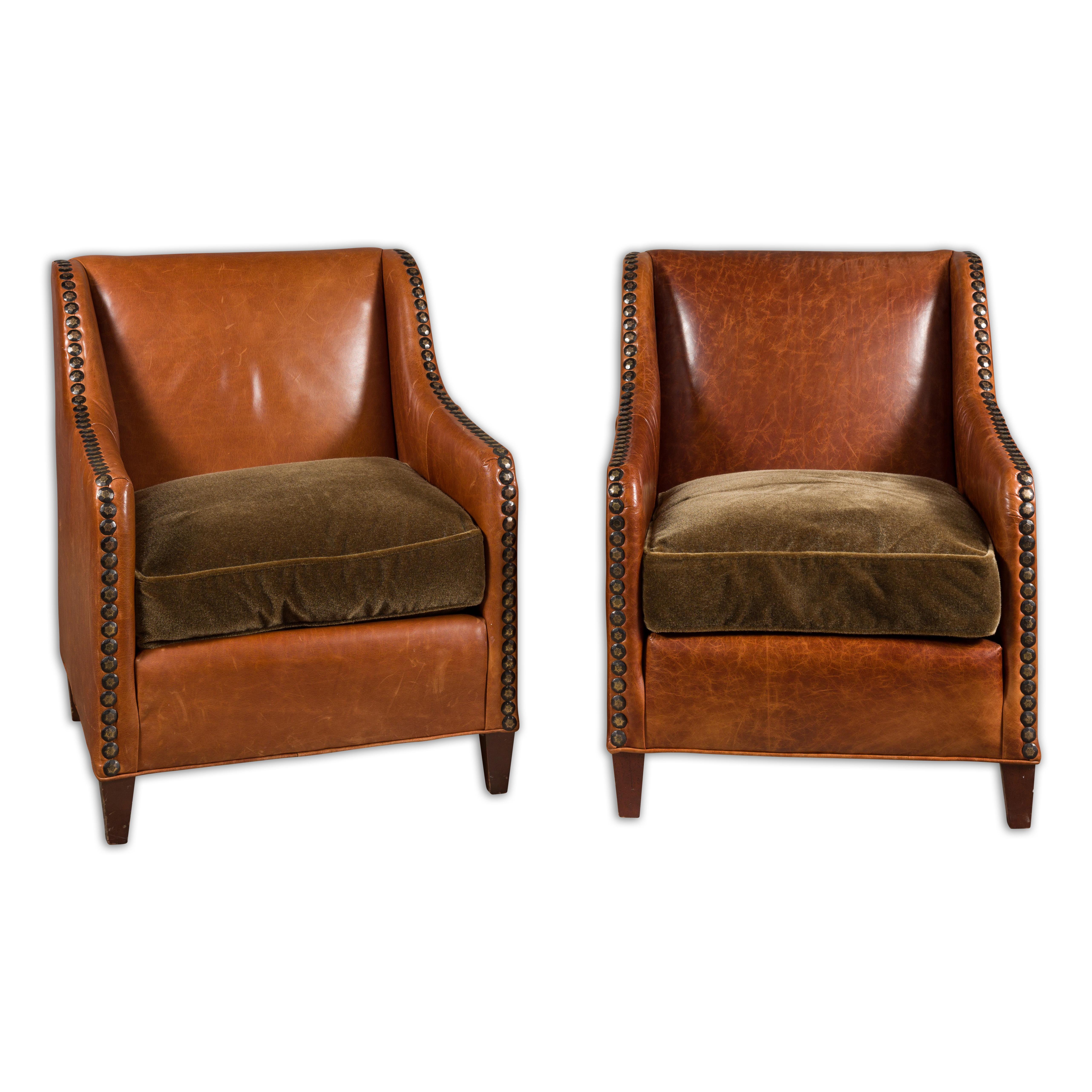 A pair of English leather club chairs from the mid 20th century with custom cushion, tapered wooden feet and nailhead trims. This pair of mid-20th-century English leather club chairs epitomizes timeless sophistication and comfort. Each chair boasts
