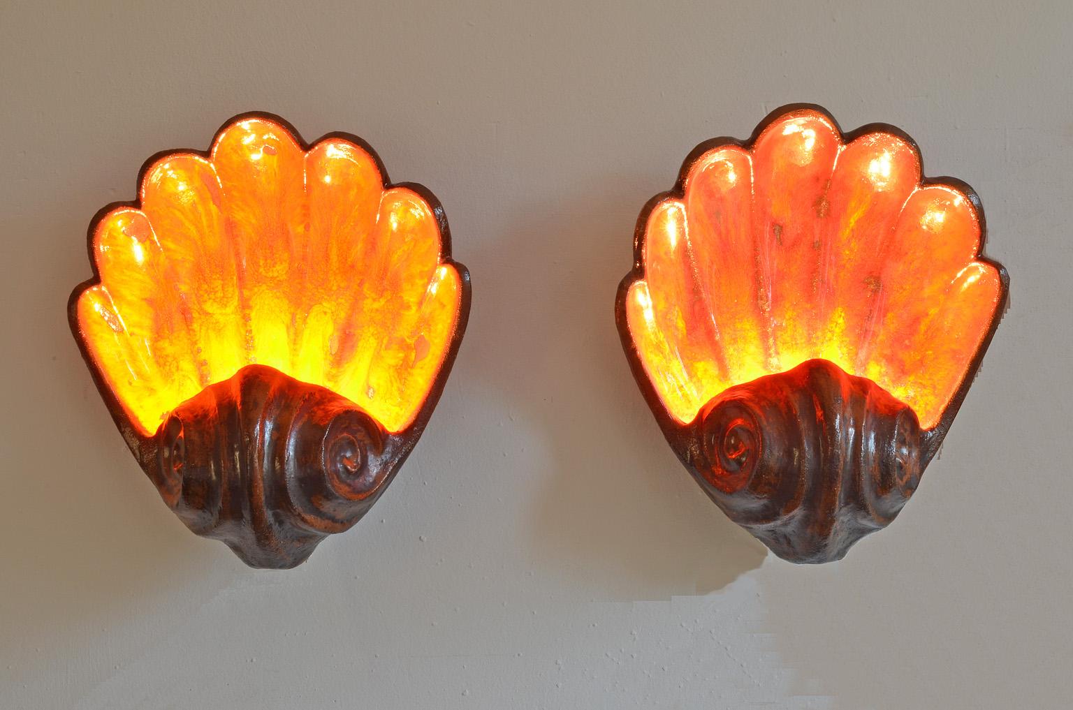 A pair of midcentury German fat lava shell sconces.
Mussel wall light, Germany 1960s.
The ceramic light is glazed in orange-red.
E27 up to max. 60 watts.


   