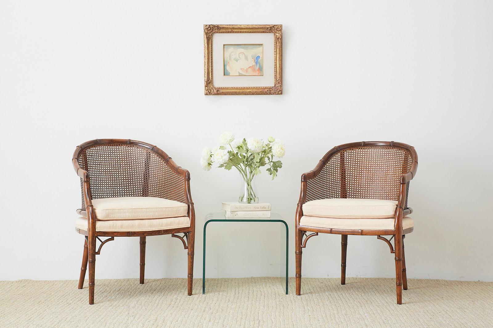 Exceptional pair of Mid-Century Modern barrel chairs by Century Furniture. Featuring a handcrafted faux-bamboo wooden frame with a caned back and sides. Made in the Hollywood Regency style with a loose seat cushion. Excellent joinery and finish from