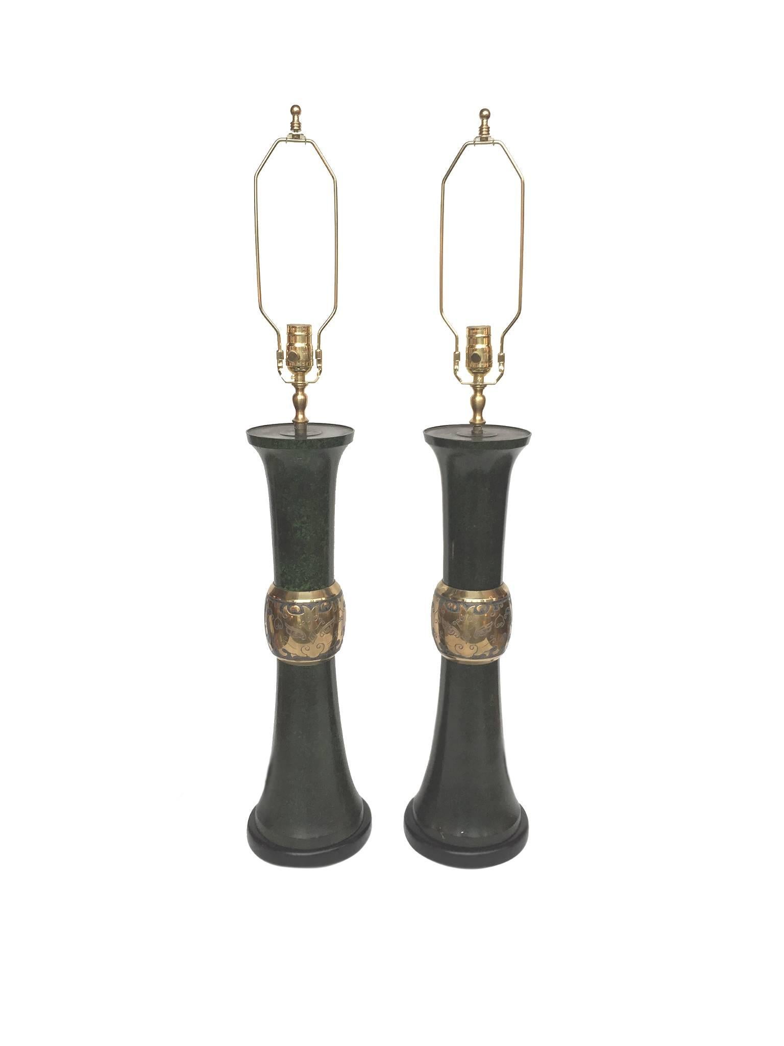 These two midcentury table lamps are comprised of metal bodies that have been finished in a rich, faux malachite green. Their bases are ebonized wood. The lamps are newly rewired and paired with new parchment shades. Their brass hardware is also new