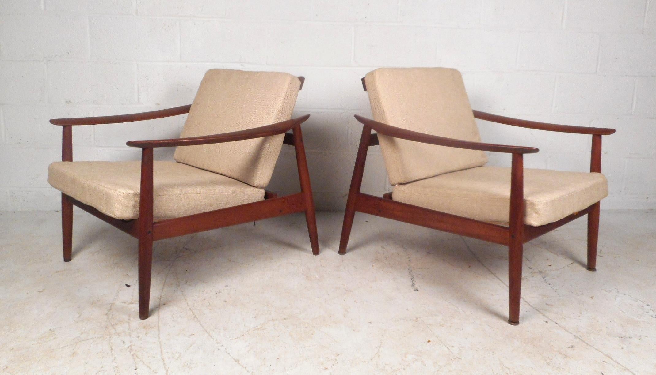 This beautiful pair of vintage modern lounge chairs feature a sculpted teak frame with an adjustable seat and backrest for maximum comfort. Sleek design with two overstuffed removable cushions covered in a plush beige fabric. This gorgeous pair has