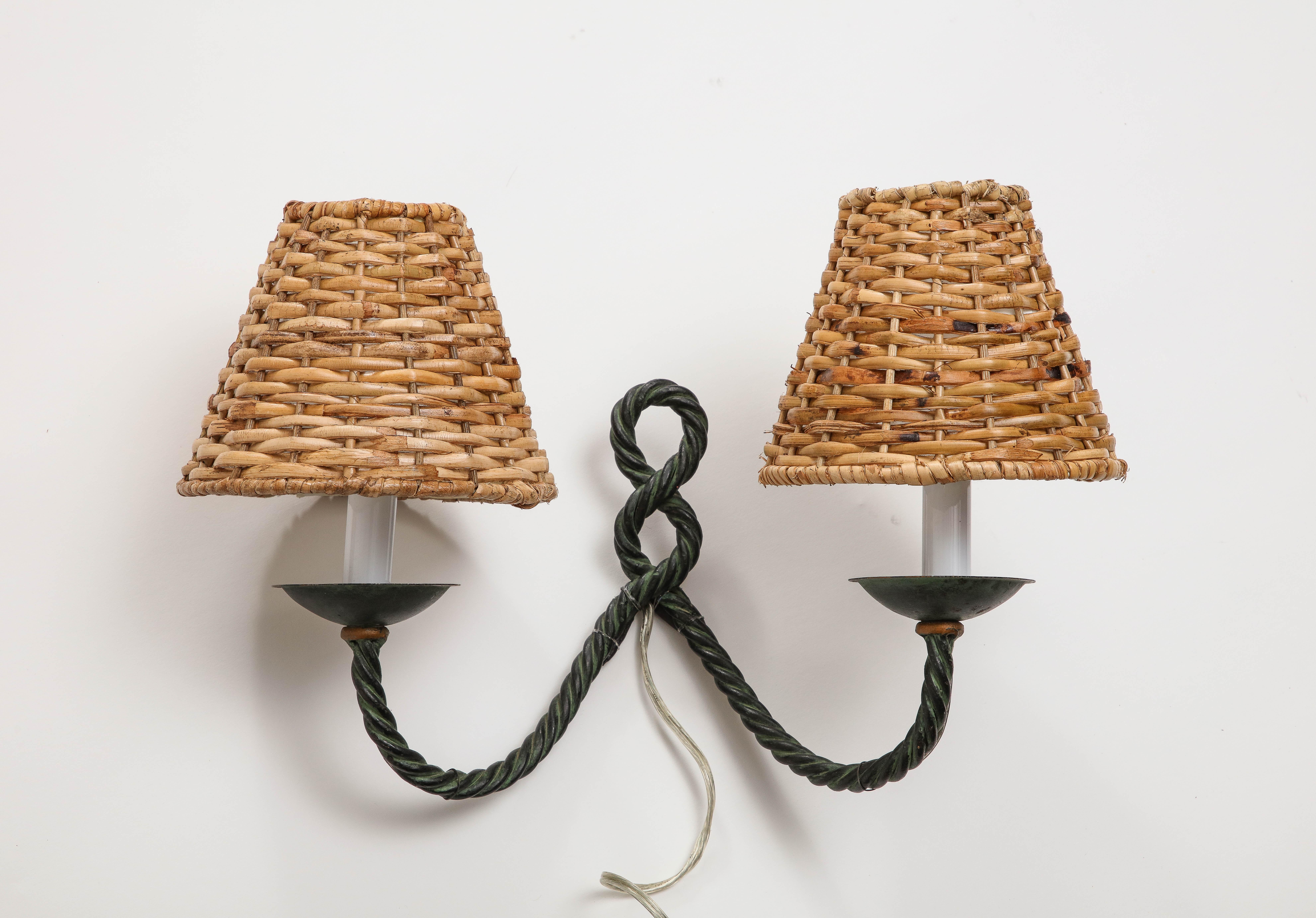 Pair of midcentury 1950s French wall sconces, with two bronze rope arms and antique patina. Two candelabra sockets per sconce; wicker lampshades included. Newly rewired for USA. 

Provenance: Atelier VIME

Measures: 8.5