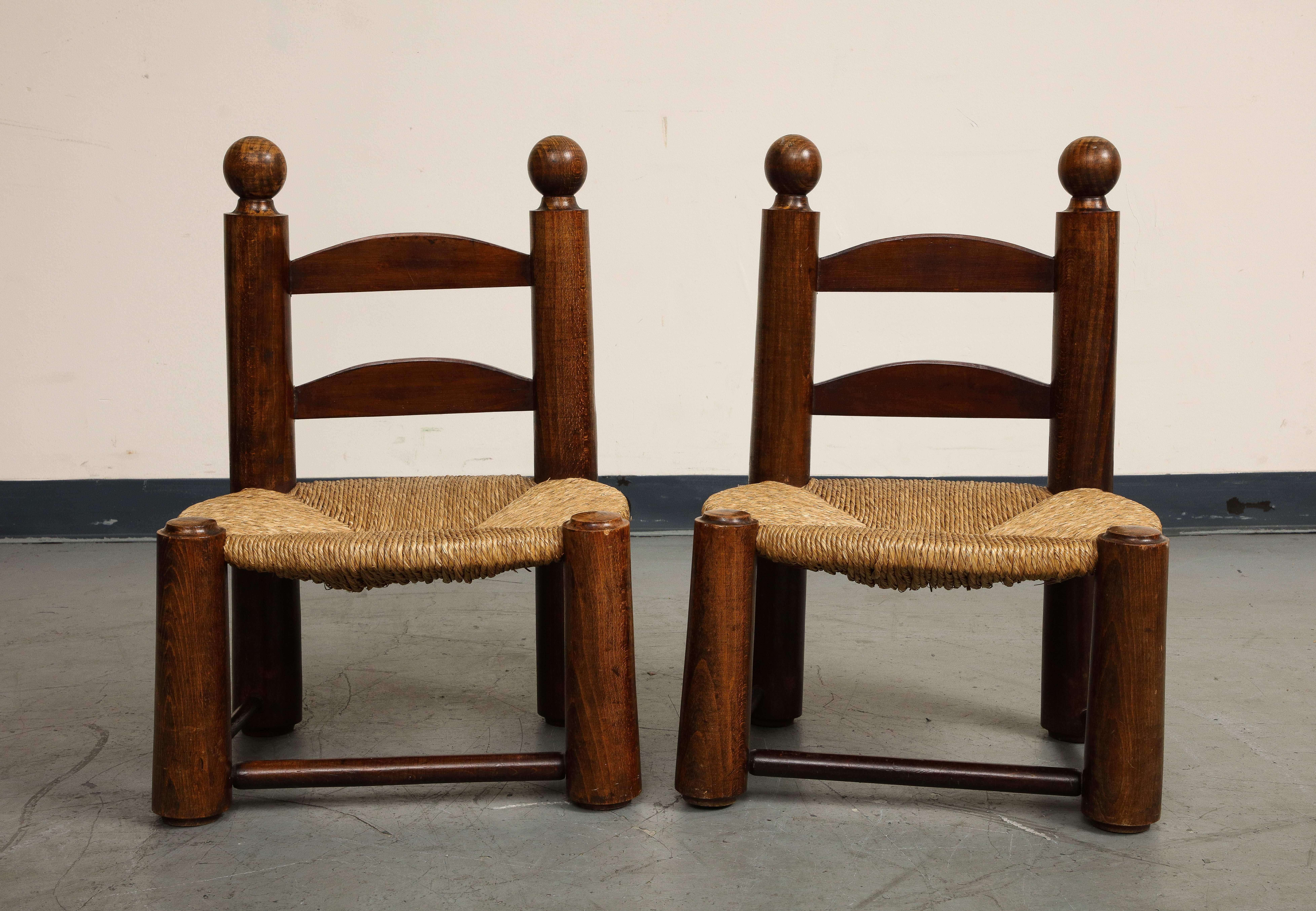 Pair of midcentury French brutalist low children's chairs by Charles Dudouyt, oak frames with rush seats. Chairs have stretchers on three sides for stability.