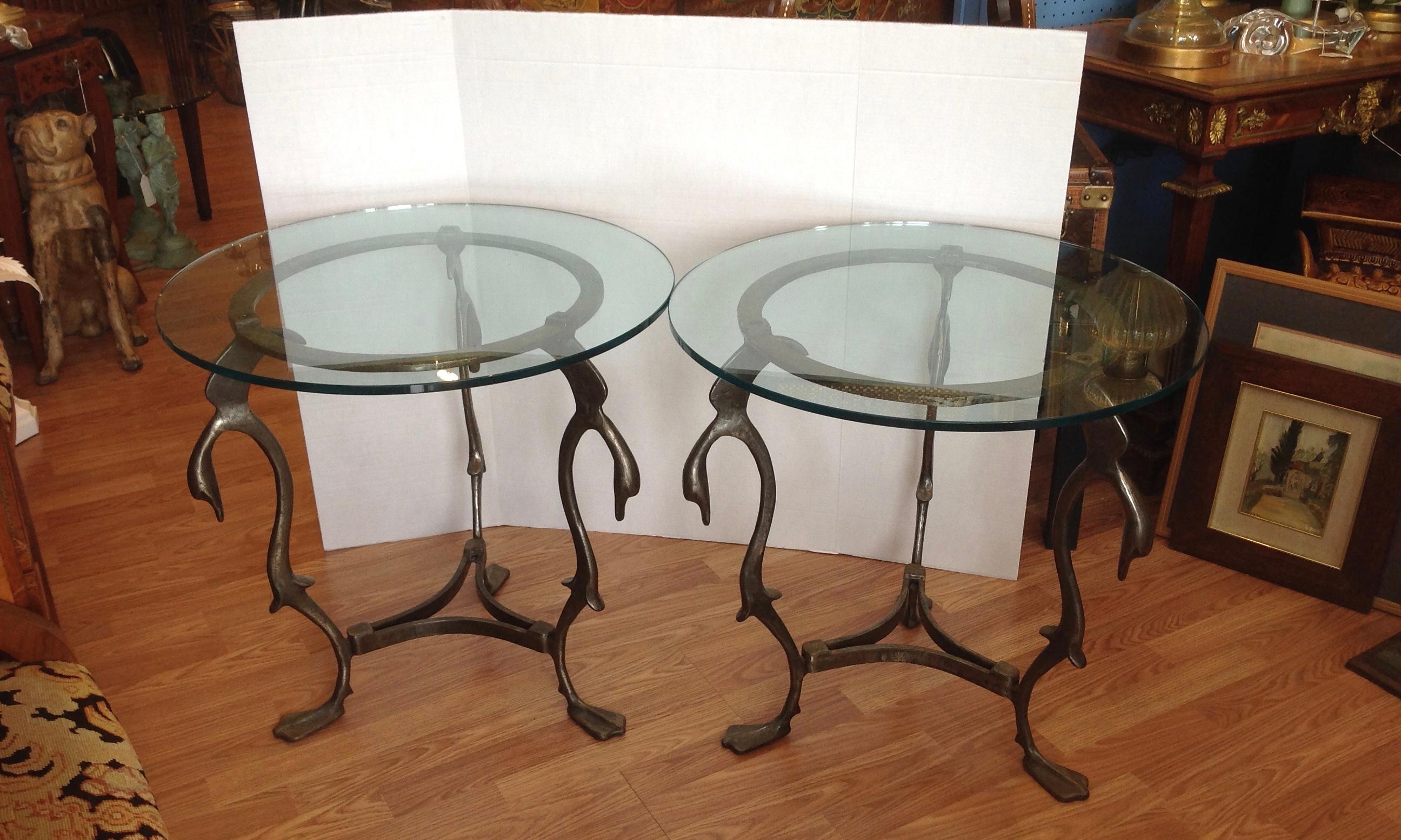 The tables are fashioned from steel and designed with 3 moderne swan form heads at the top;
and terminate in web feet at their bases.
The tables are mounted with glass tops.