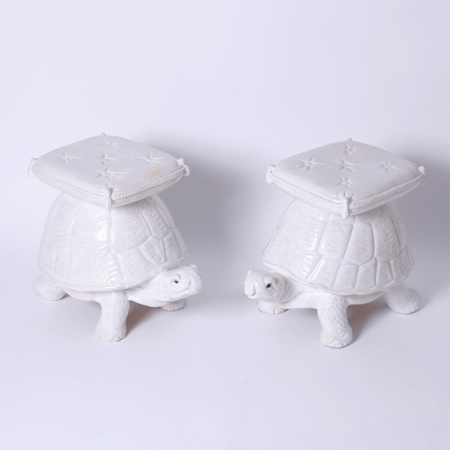 Whimsical pair of turtle benches or garden seats crafted in terra cotta and glazed white while balancing button tufted pillows with tassels. The amusing faces are sporting striking green eyes.