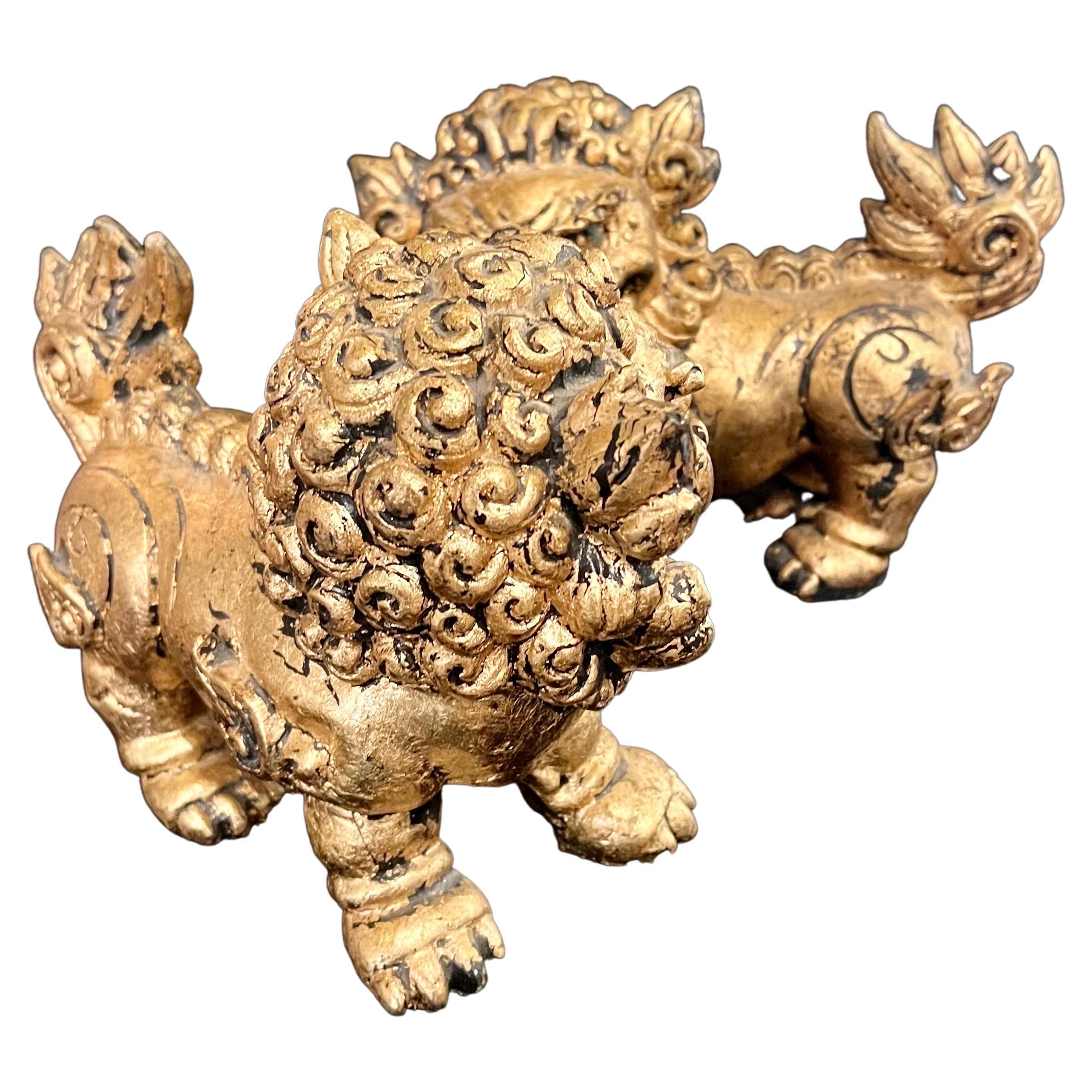Great pair of mid-century style foo dogs or bookends made in China, circa the 1980s. Great detail and a beautiful gold leaf finish made out of a resin.
 