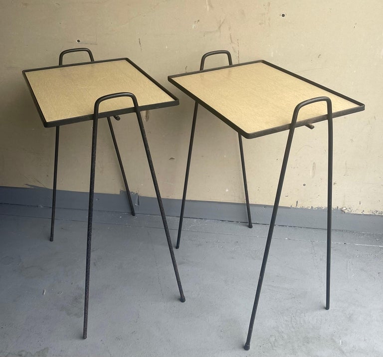 A very cool and functional pair of mid-century hairpin stacking TV tray tables, circa 1960s. The table frames are made of welded steel and the tray tops of laminated blonde wood. The set is in fair vintage condition with plenty of patina. Nice